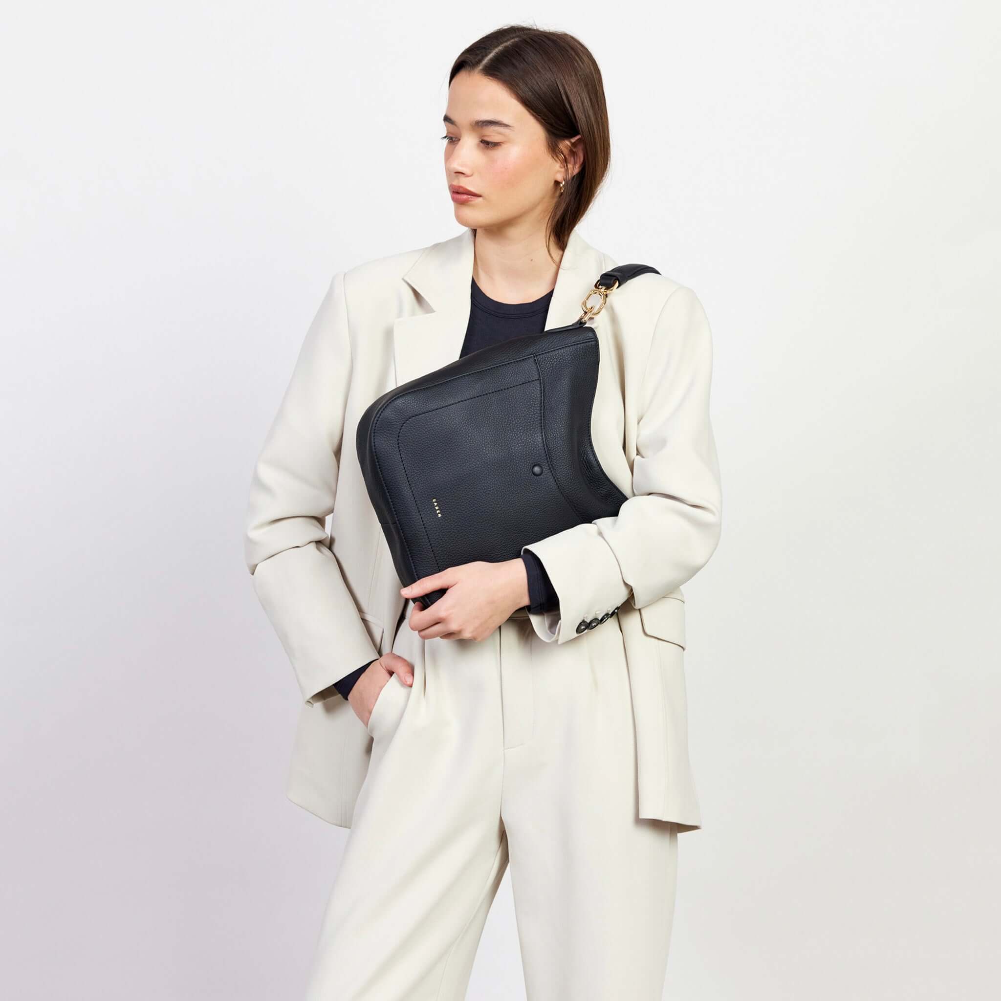 Alt Tag: Saben Rebe Shoulder Bag - Black in black pebbled leather worn crossbody on model, hobo-style with detachable strap