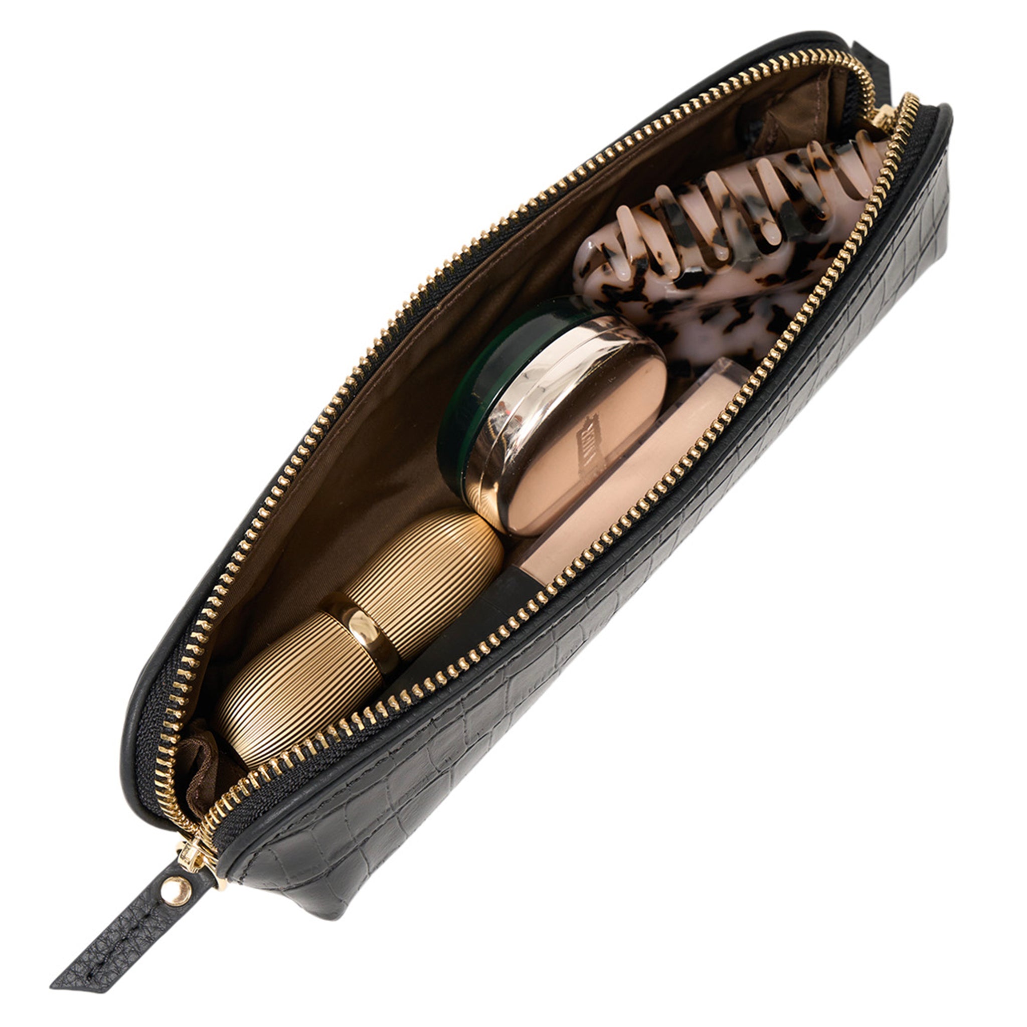 Black makeup bag with gold and silver makeup items on a white background