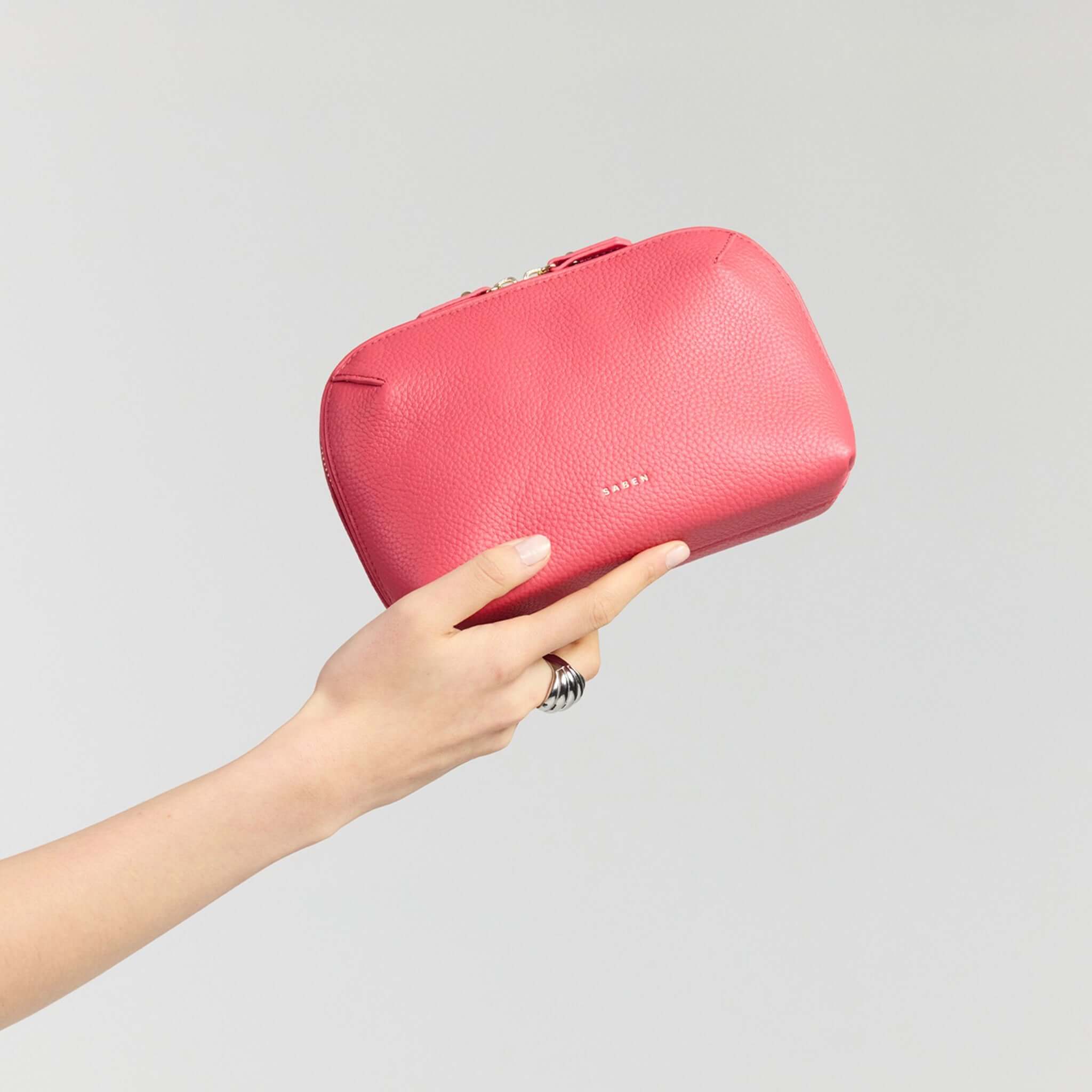 Saben Tate Tech / Cosmetic Pouch - Azalea being held, showcasing its vibrant pink leather design.