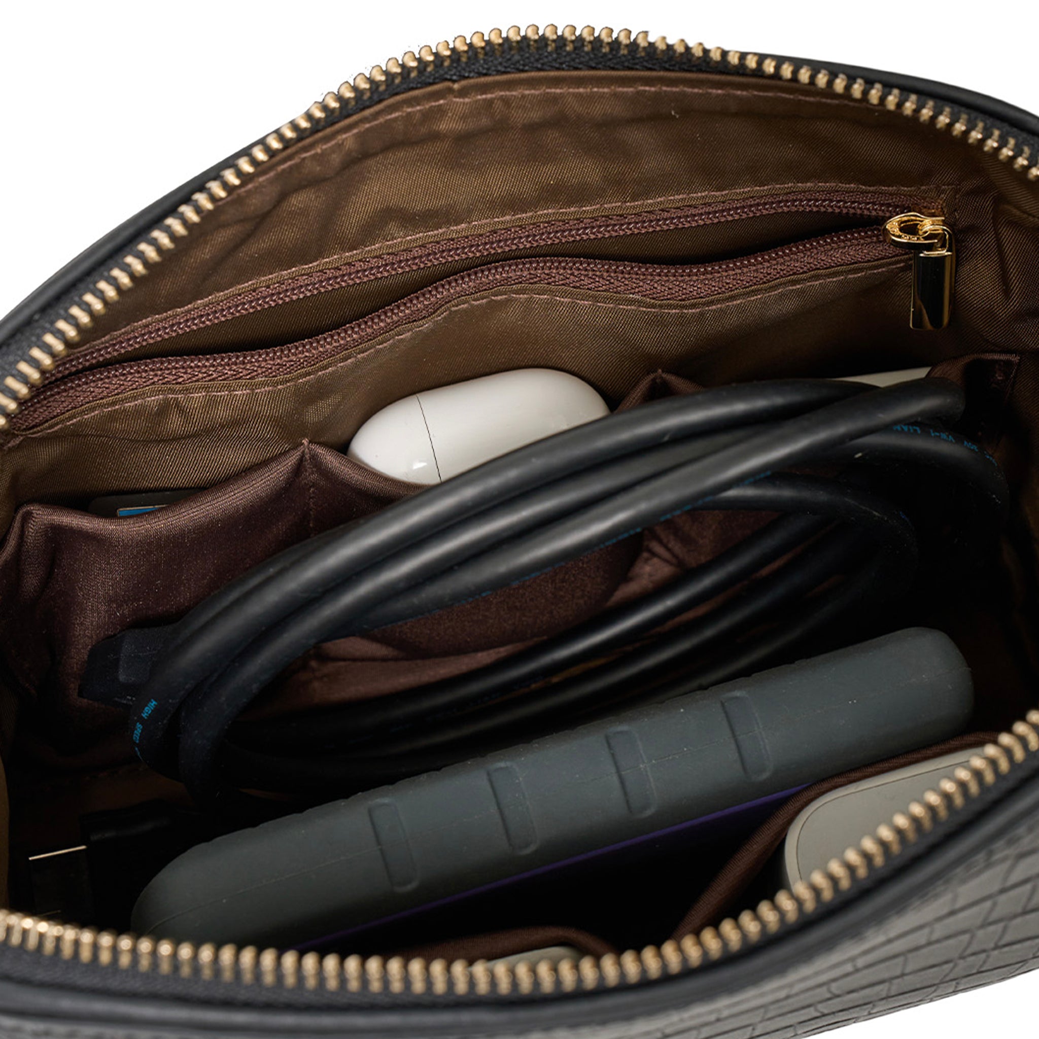 Open brown leather bag with electronic devices inside on a white background