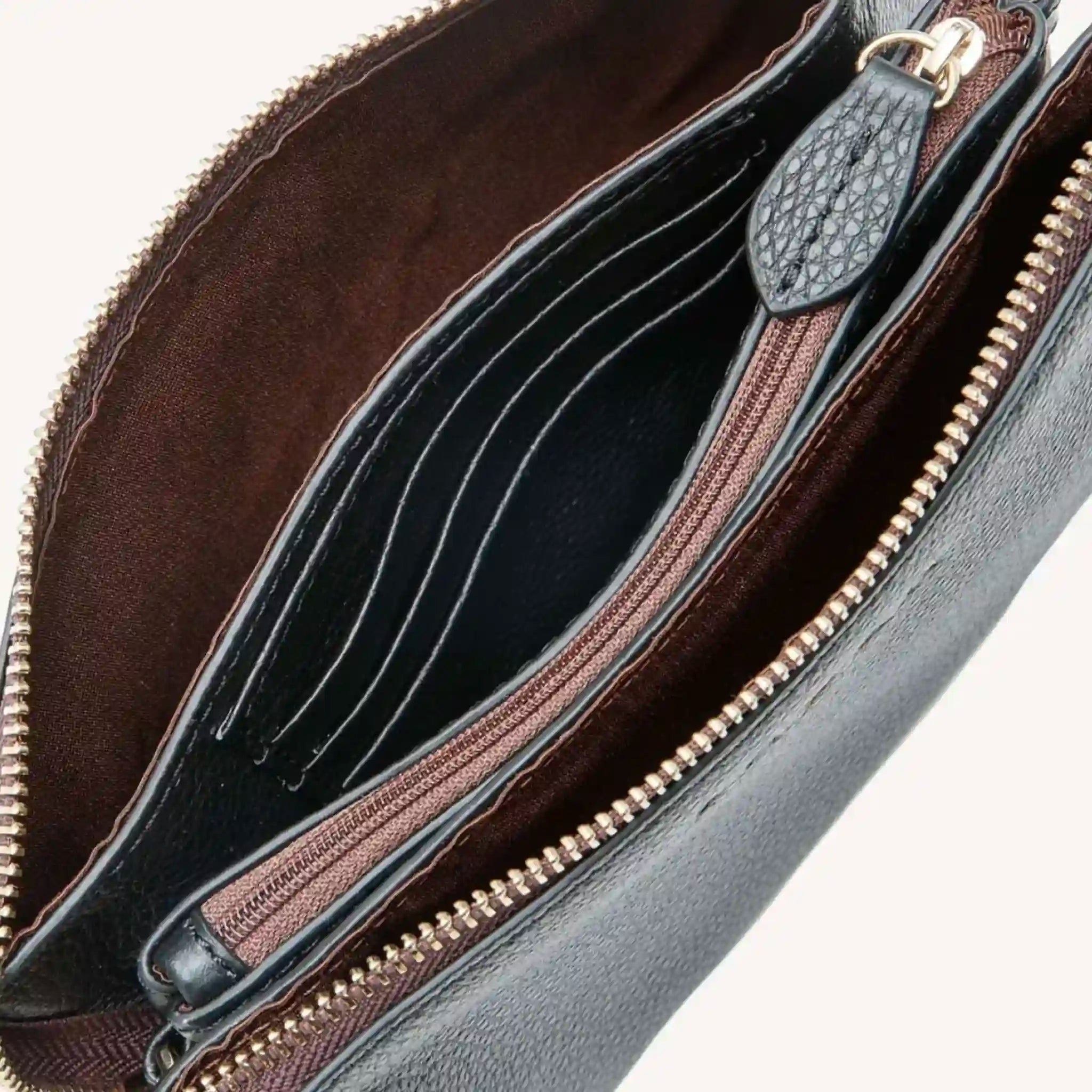 Close-up of a leather handbag with a zipper, showing the interior.