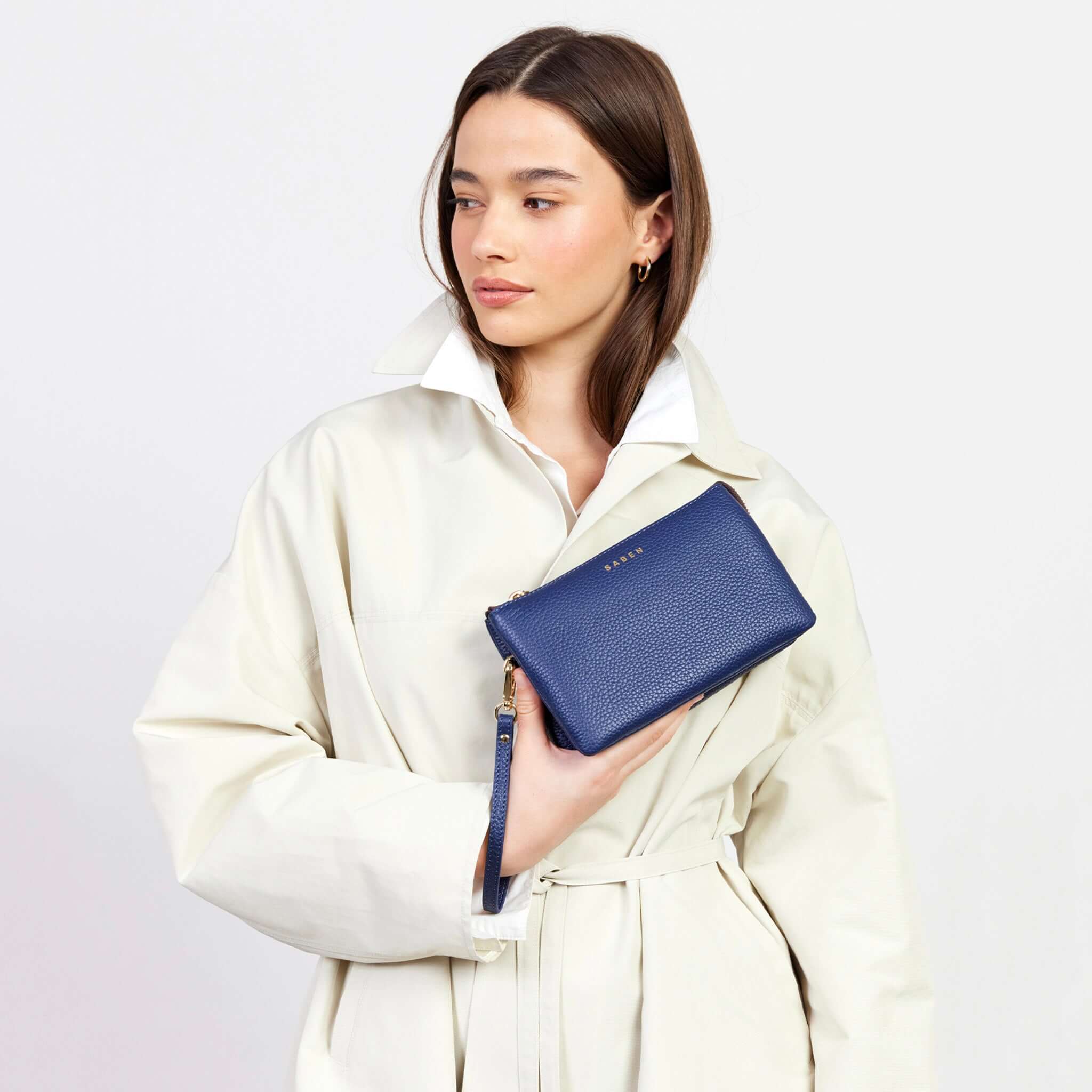 Saben Tilly Crossbody Bag - Ink held by a model, showcasing its stylish design and multifunctional use.