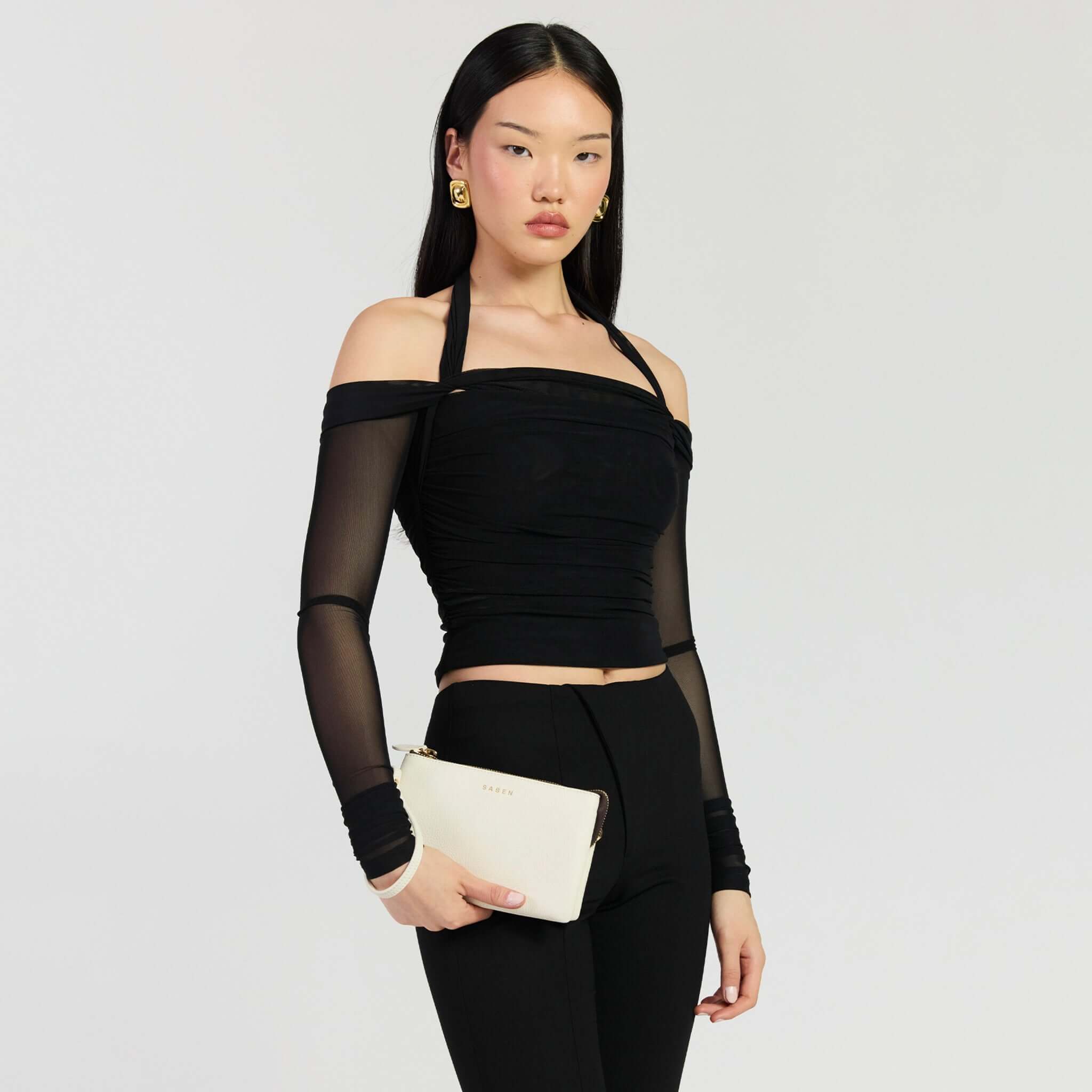 Saben Tilly Crossbody Bag - Quartz being held by a model in a stylish outfit, showcasing versatility and elegance.
