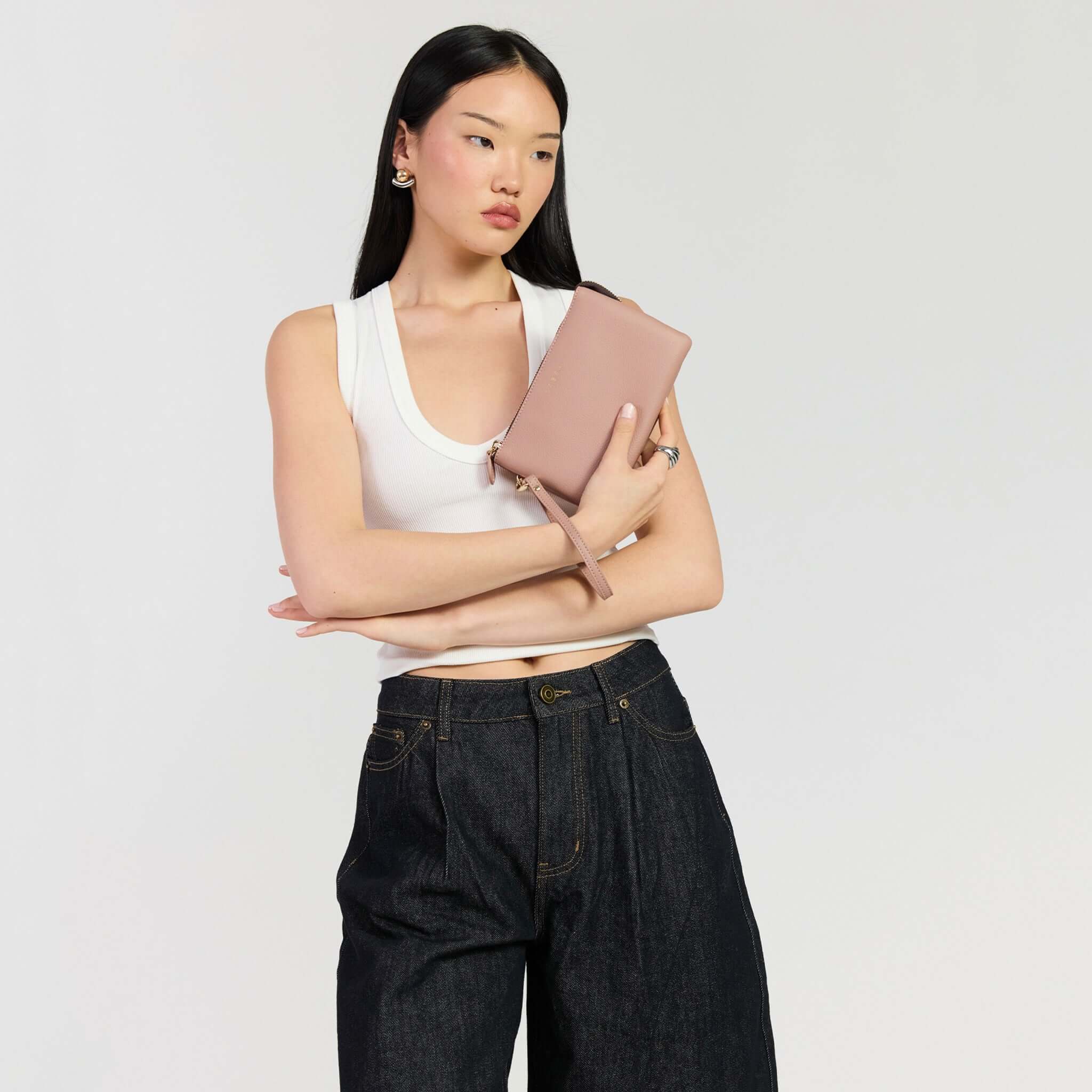 Saben Tilly Crossbody Bag - Rosewater held by a model wearing casual attire, showcasing versatility and style.