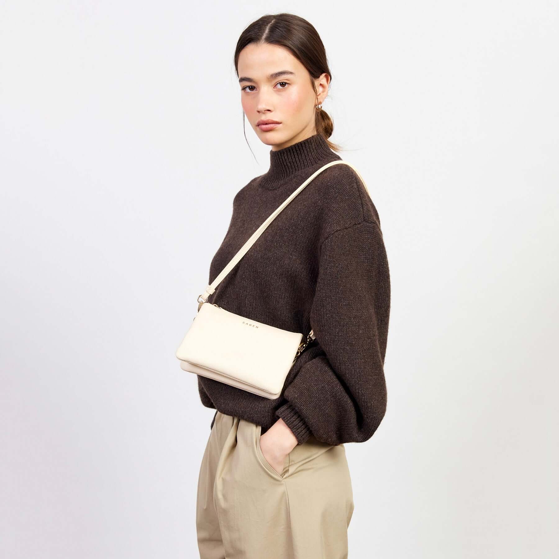 Saben Tilly Crossbody Bag - Vanilla worn as a crossbody on model, vanilla leather wallet clutch bag with adjustable strap