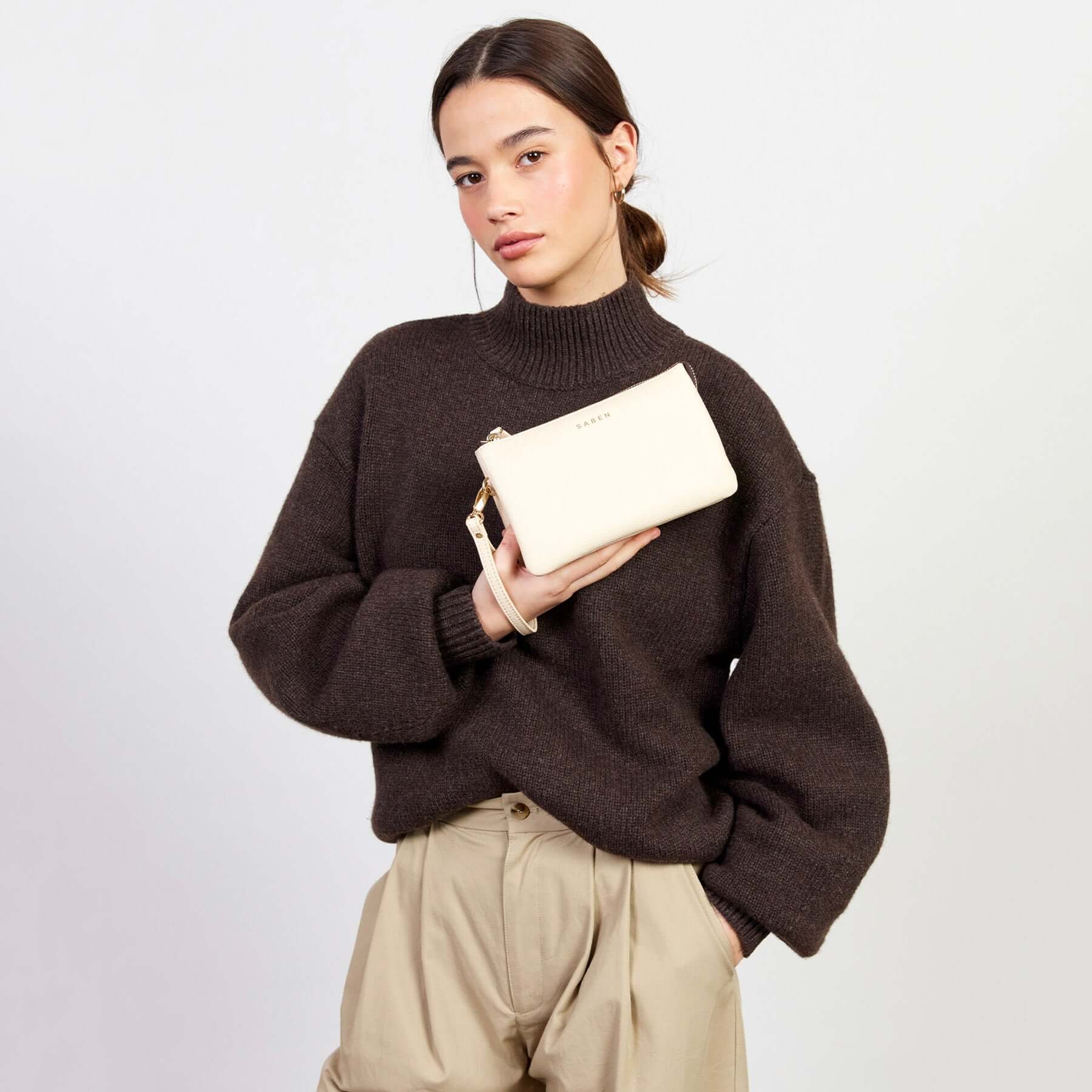 Alt Tag: Model holding Saben Tilly Crossbody Bag - Vanilla leather wallet clutch crossbody in vanilla