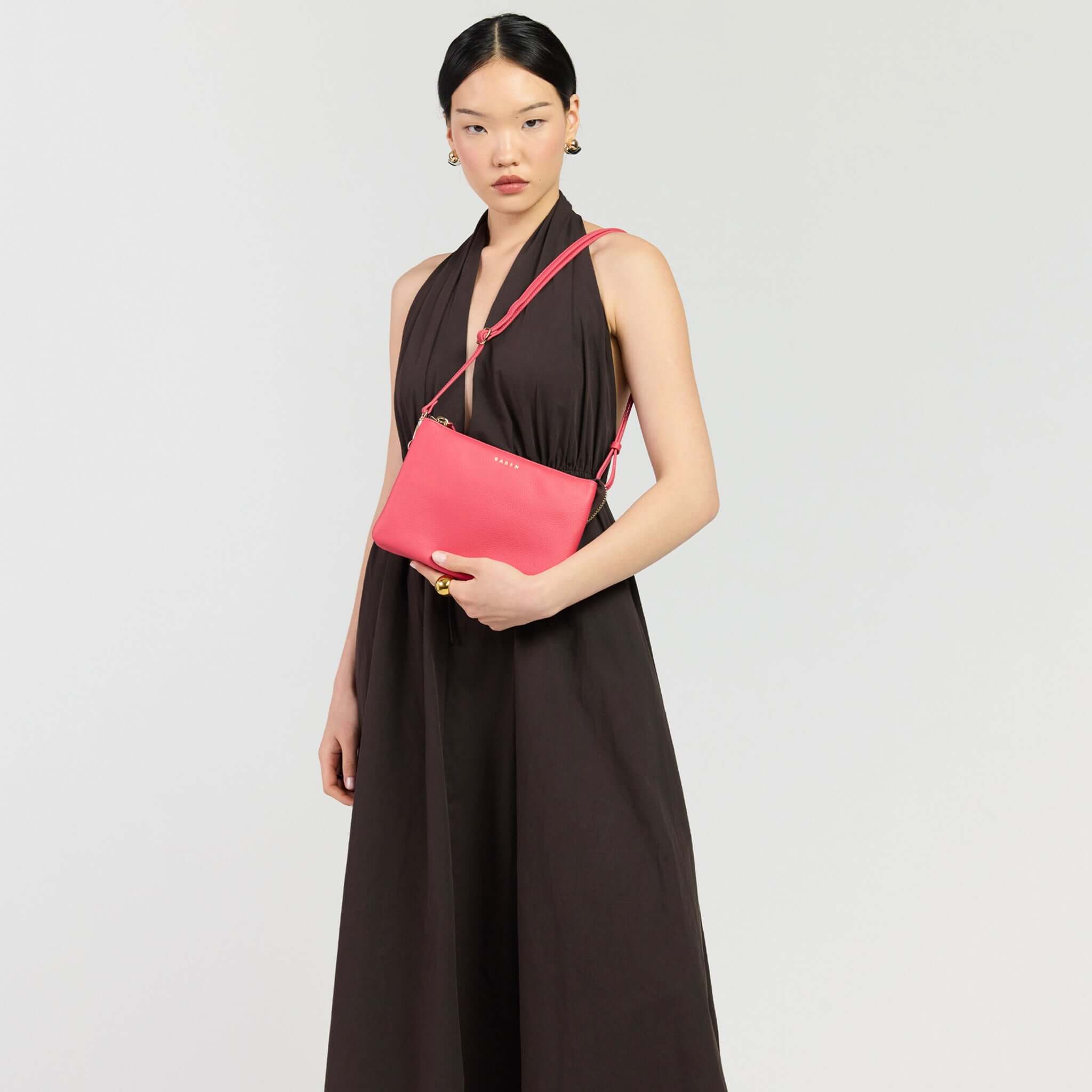 Saben Tilly's Big Sis Crossbody Bag - Azalea worn by a model in a stylish outfit.