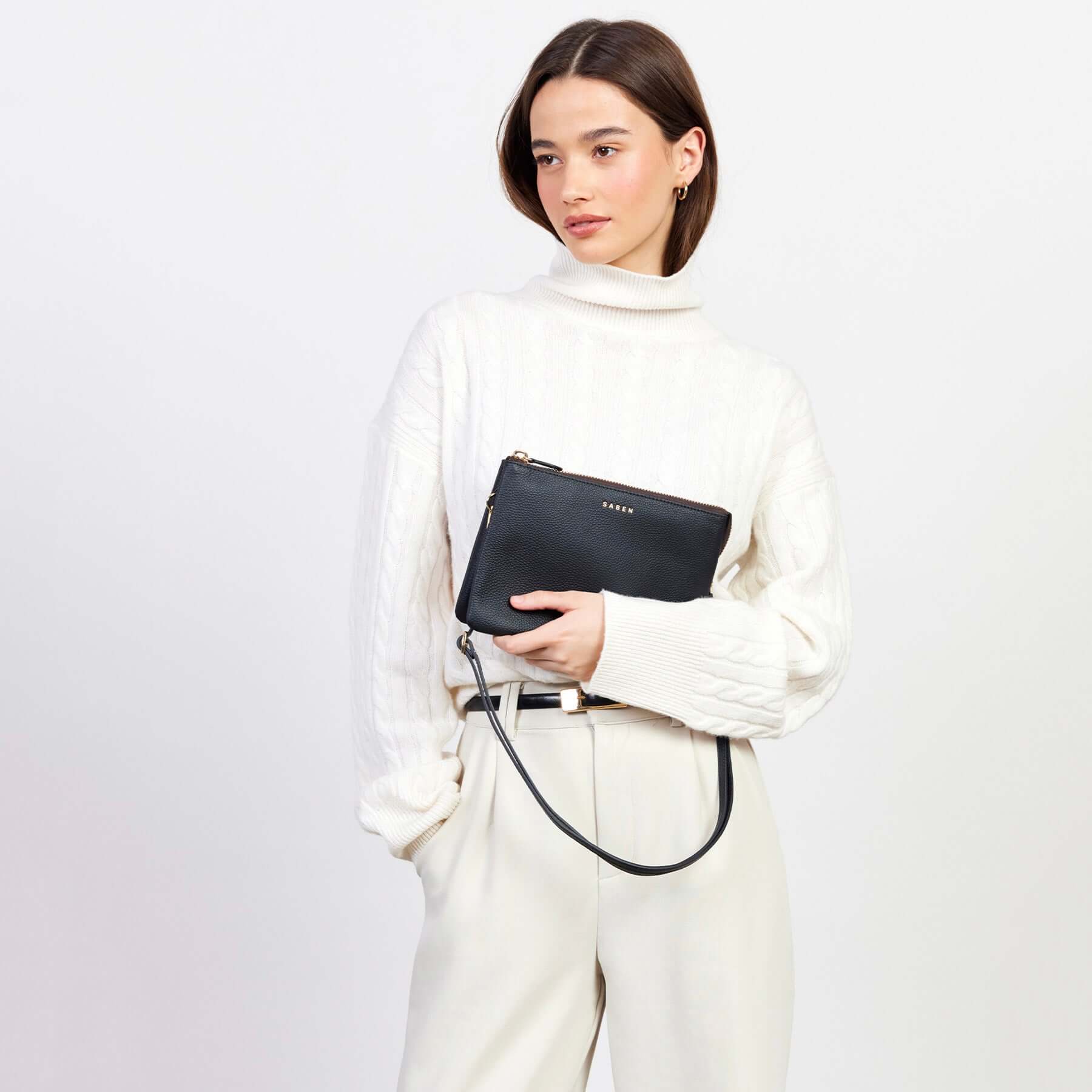 Alt Tag: Model holding Saben Tilly's Big Sis Crossbody Bag - Black pebbled leather clutch with crossbody strap
