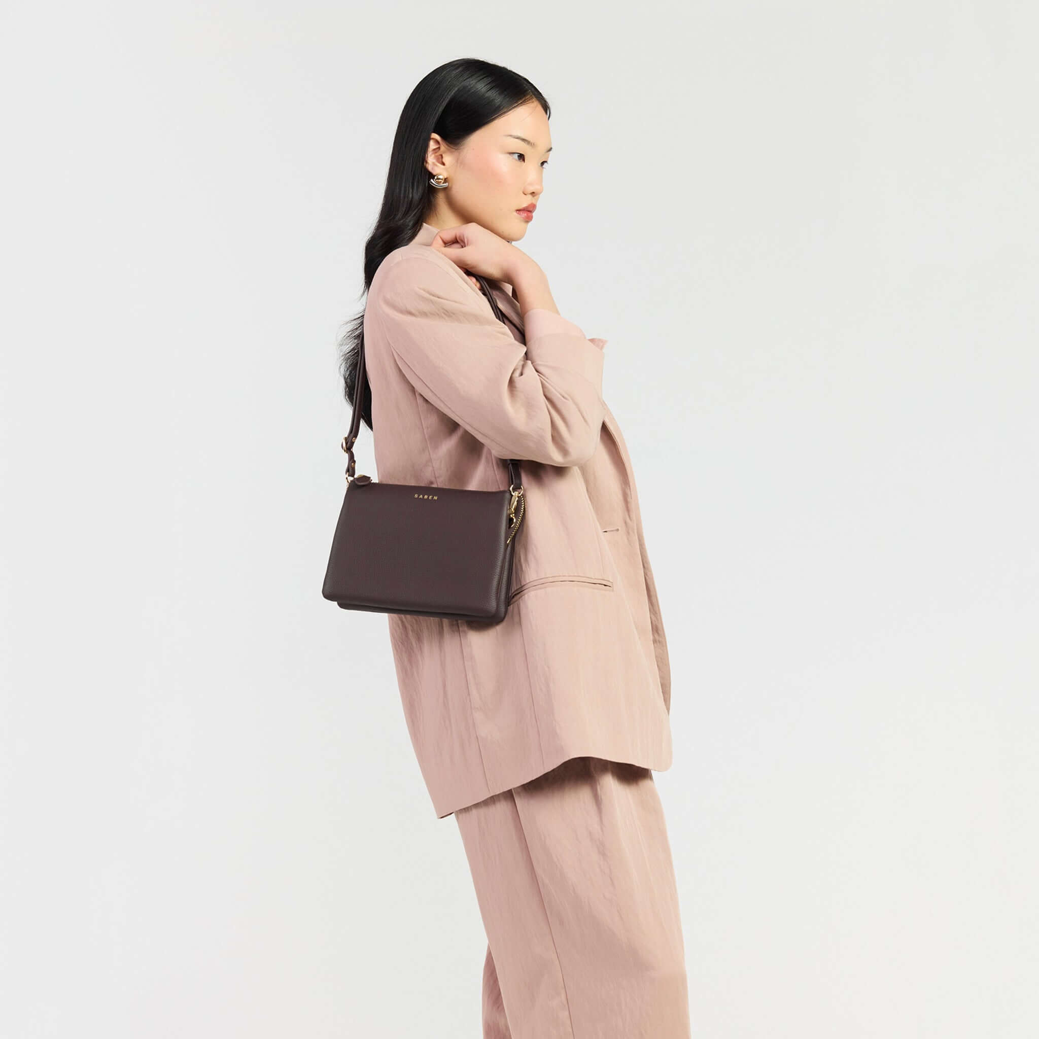 Saben Tilly's Big Sis Crossbody Bag - Cacao held by a model wearing a stylish blazer.