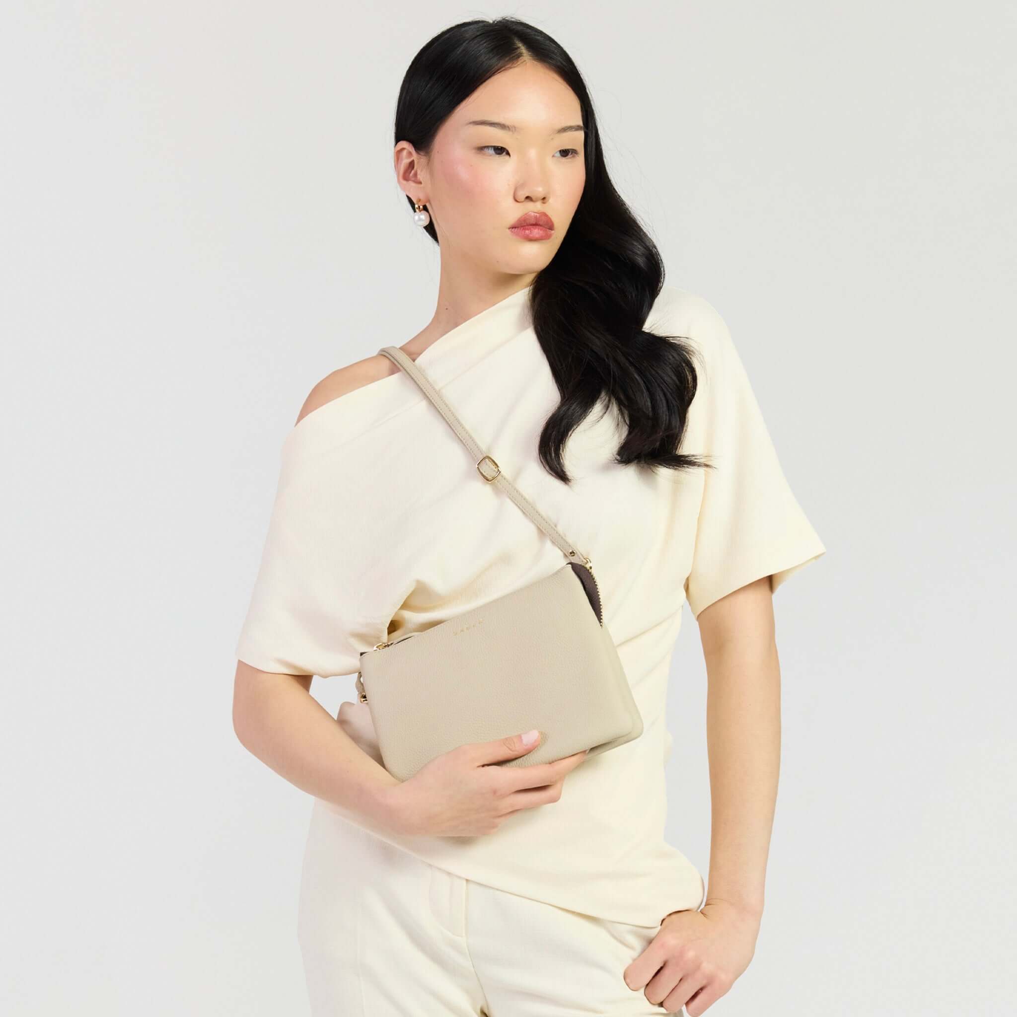 Saben Tilly's Big Sis Crossbody Bag - Oyster worn by model in cream outfit, showcasing its elegant and stylish design.