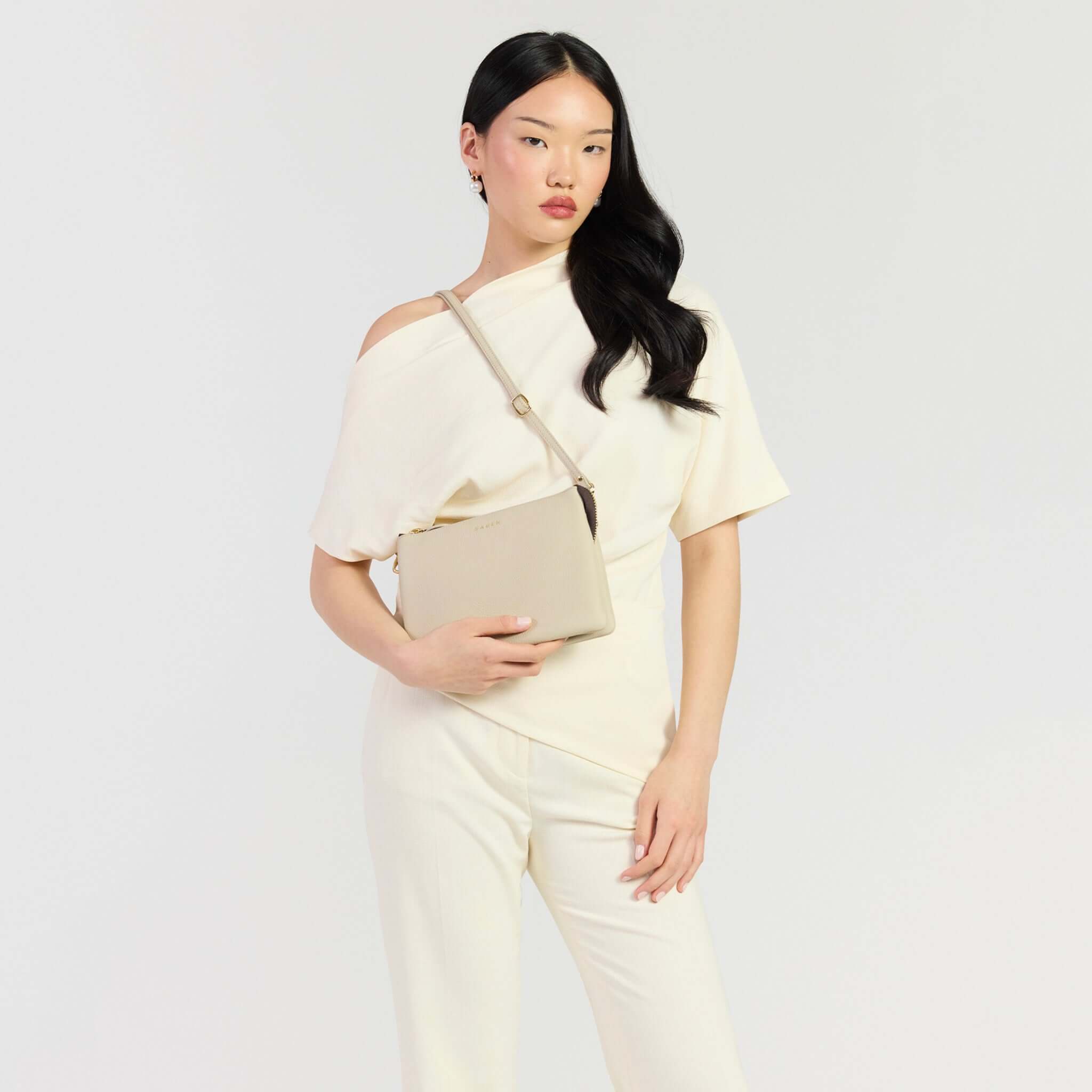 Saben Tilly's Big Sis Crossbody Bag - Oyster on model wearing a stylish off-shoulder top, showcasing elegance.