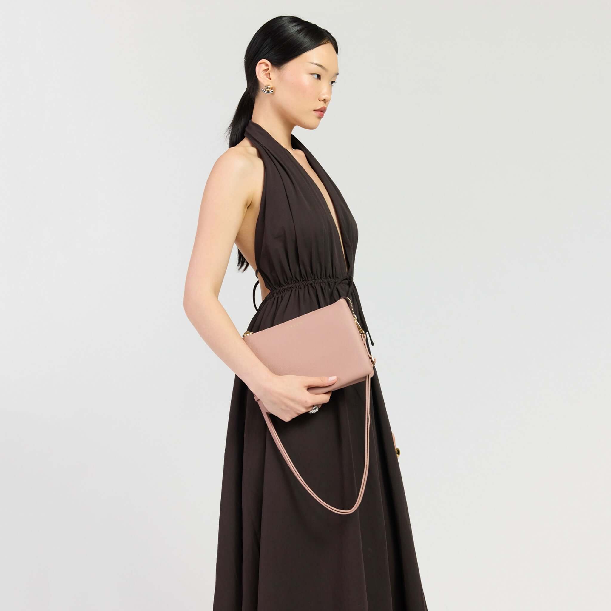 Saben Tilly's Big Sis Crossbody Bag - Rosewater held by a model in a chic dress.