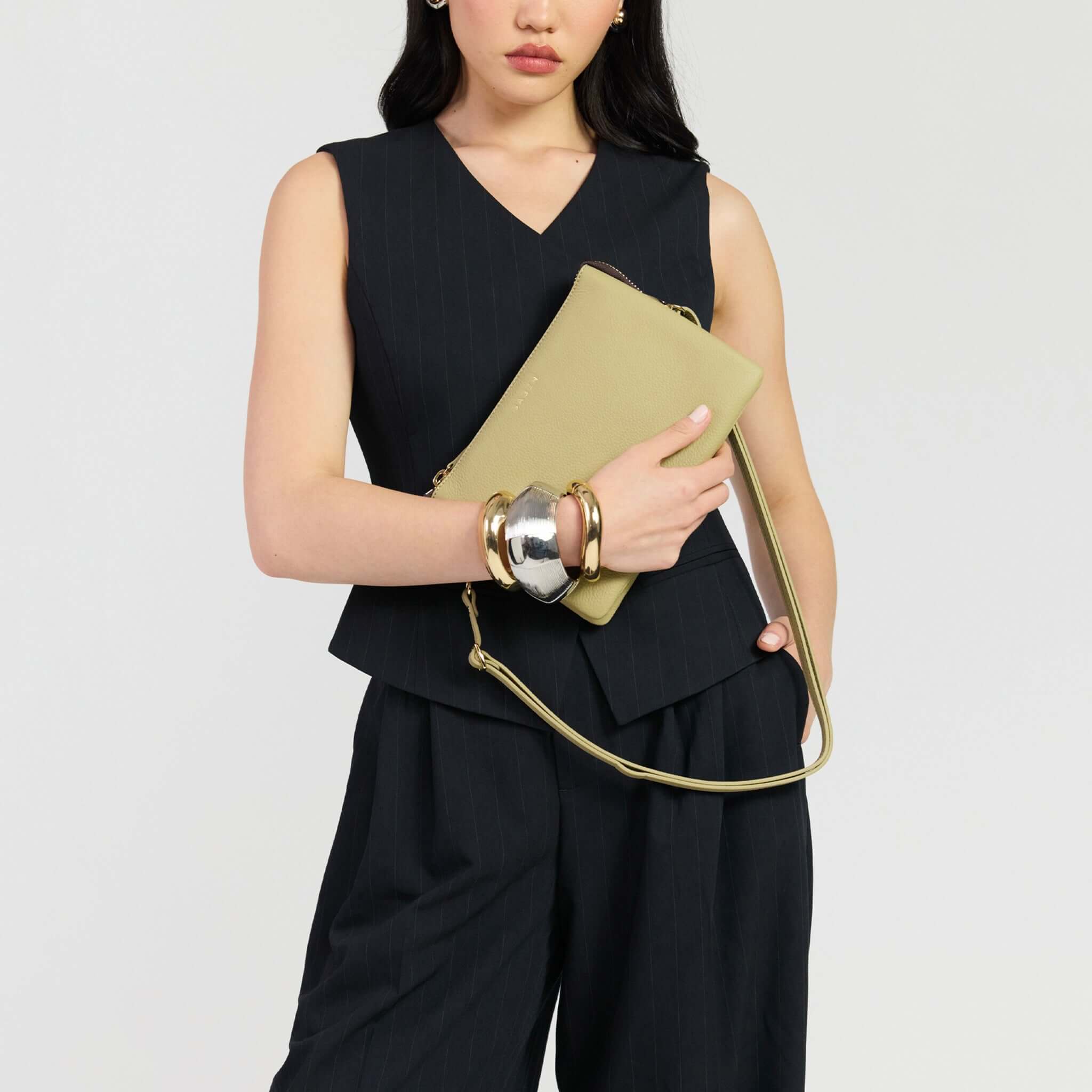 Model holding Saben Tilly's Big Sis Crossbody Bag - Willow with stylish outfit and accessories.