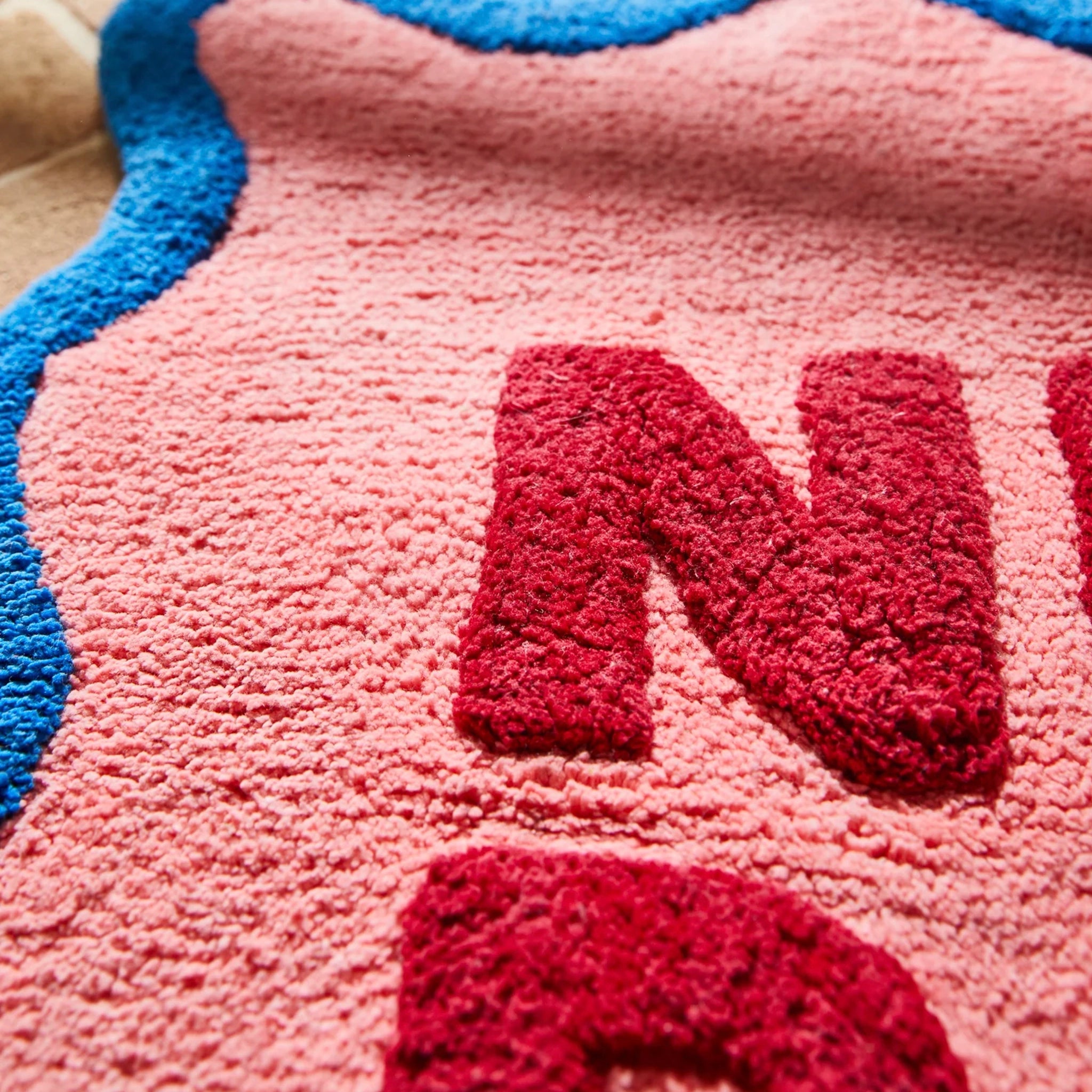 Close-up of a textured pink surface with red letters spelling 'NAN'.