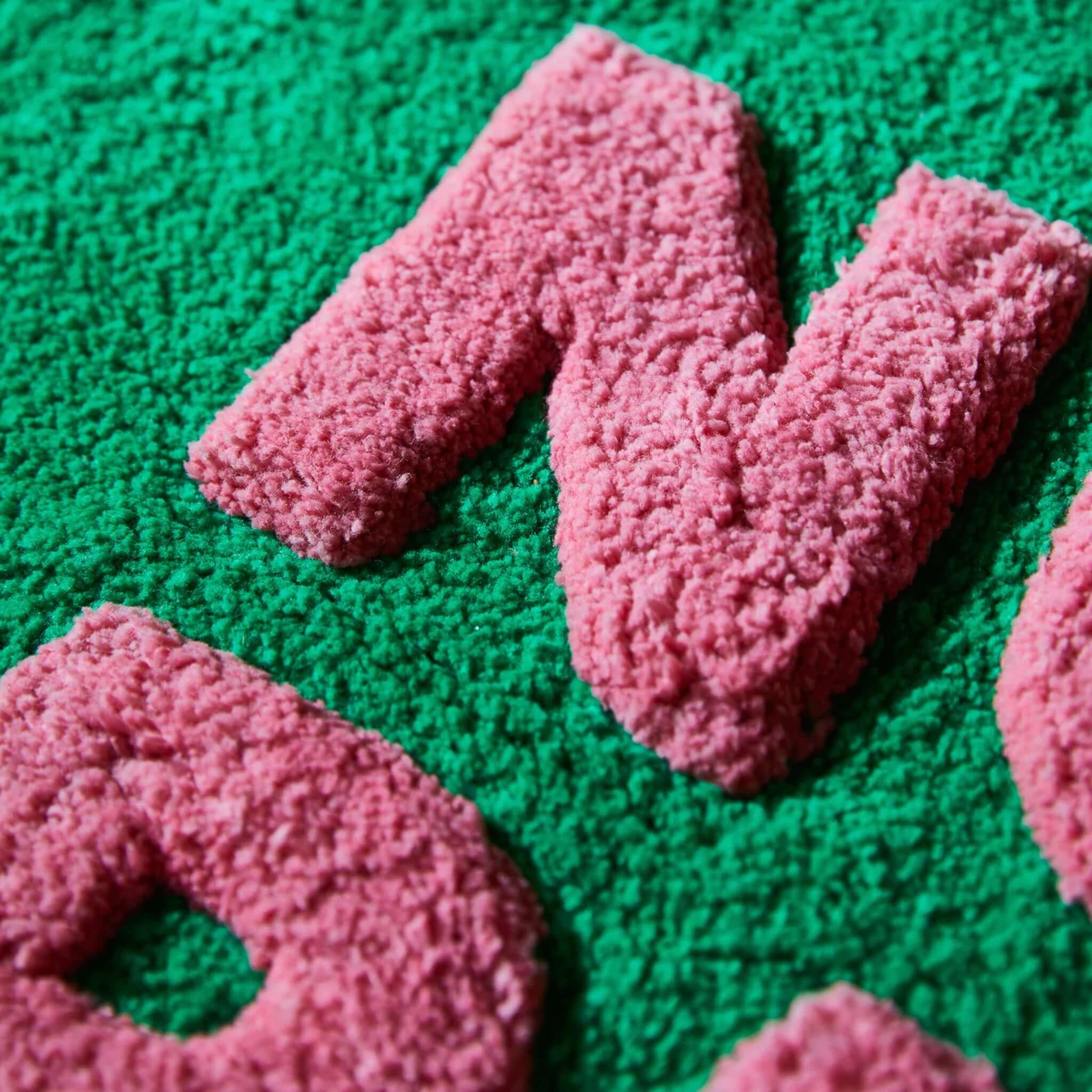 Close-up of the Sage x Clare Amalie Nudie Bath Mat - Spring Green showcasing the plush texture in pink and green.