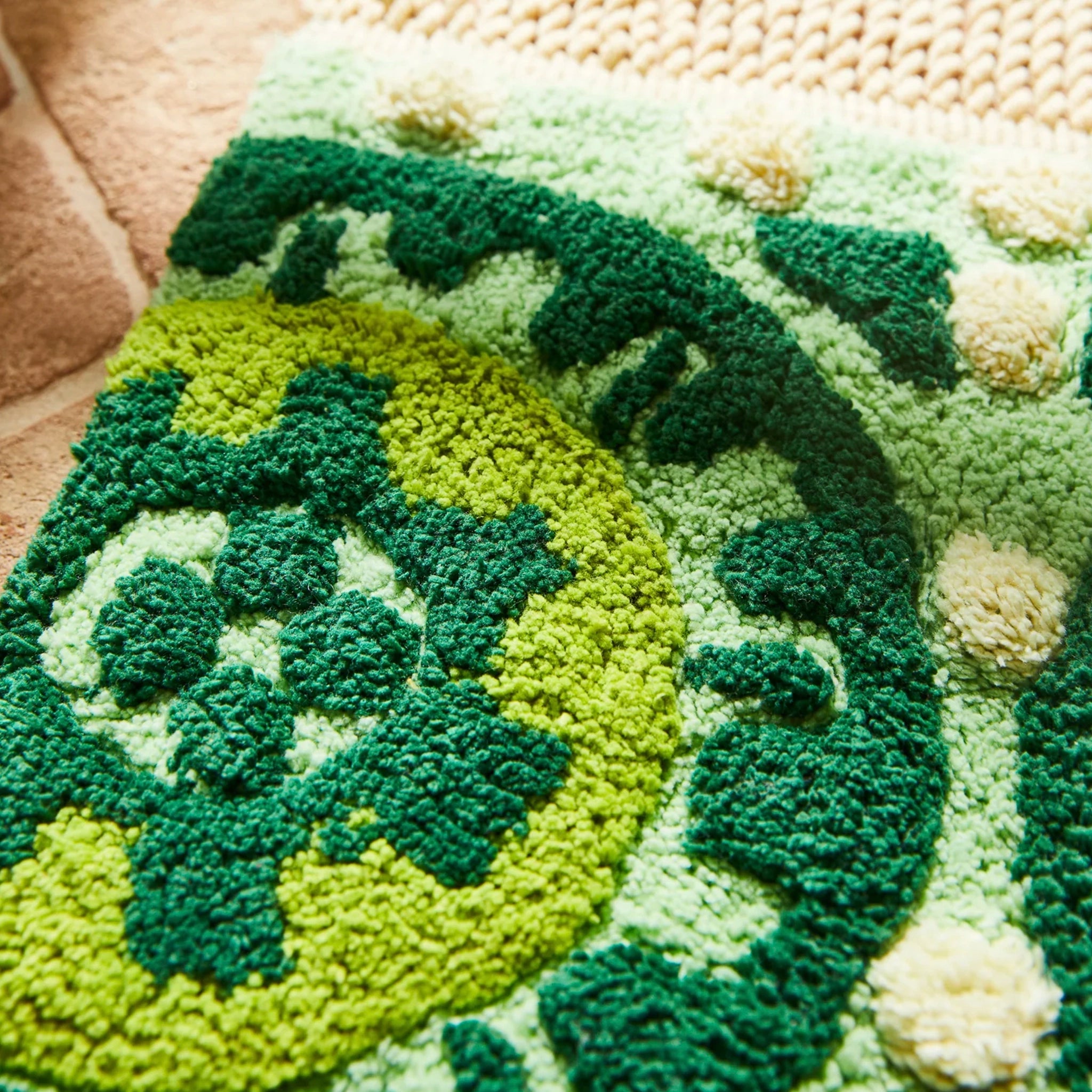 Close-up of a textured green and beige bath mat with a pattern