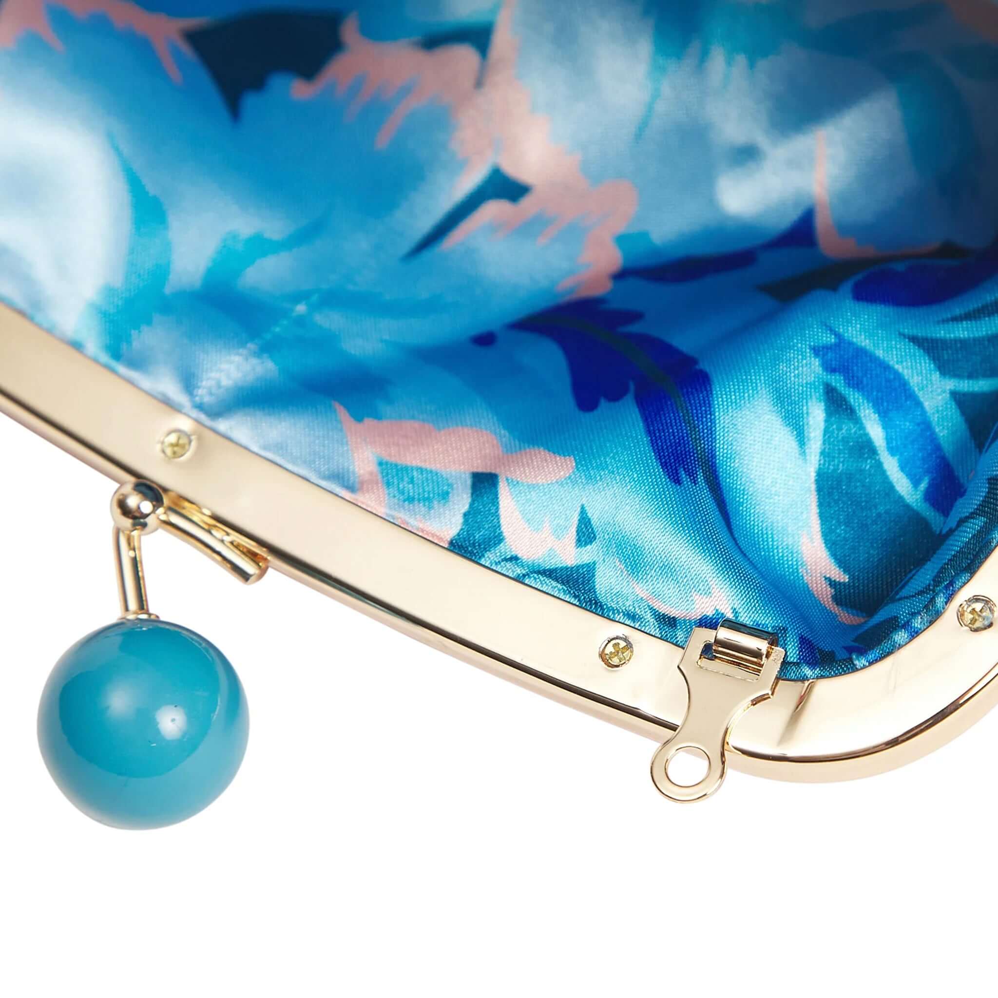 Inside view of the Sage x Clare Bonny Large Purse - Poppy featuring vibrant blue floral lining and a teal bobble clasp.