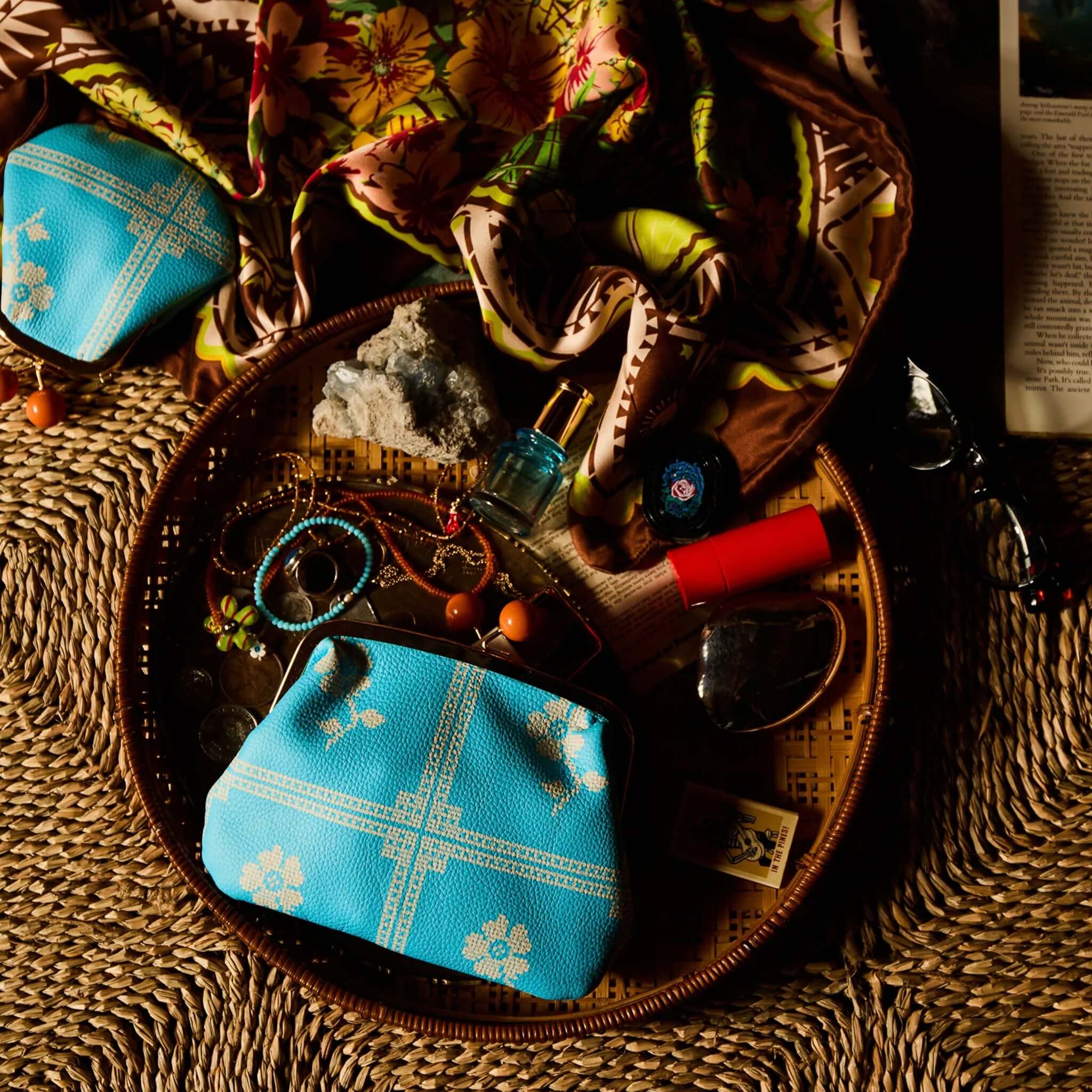 Sage x Clare Bonny Large Purse - Turquoise styled with accessories on a woven tray.