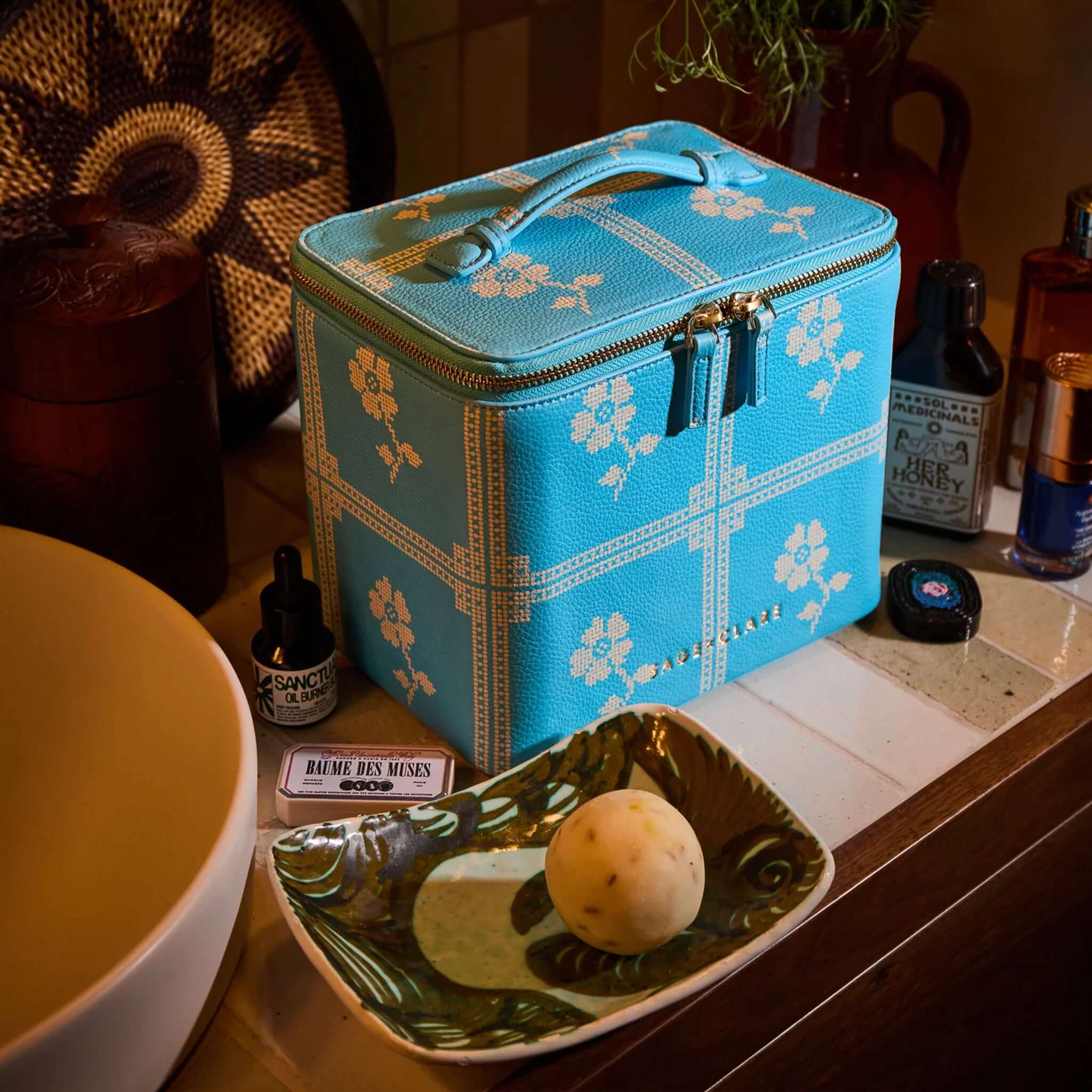 Sage x Clare Bonny Medium Vanity Case - Turquoise displayed on a countertop with beauty products and decor.