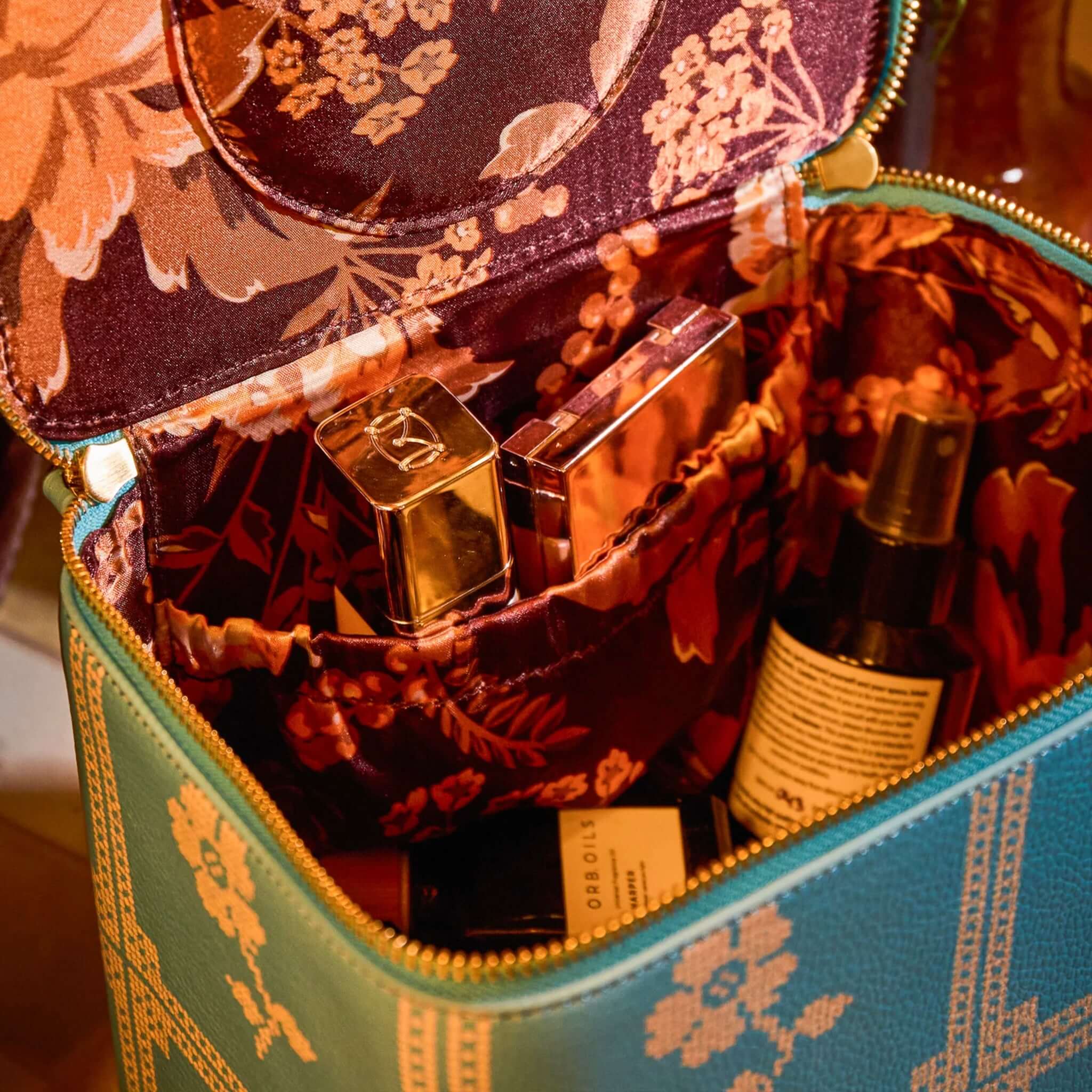 Sage x Clare Bonny Medium Vanity Case - Turquoise with beauty products inside, showcasing elegant floral interior.