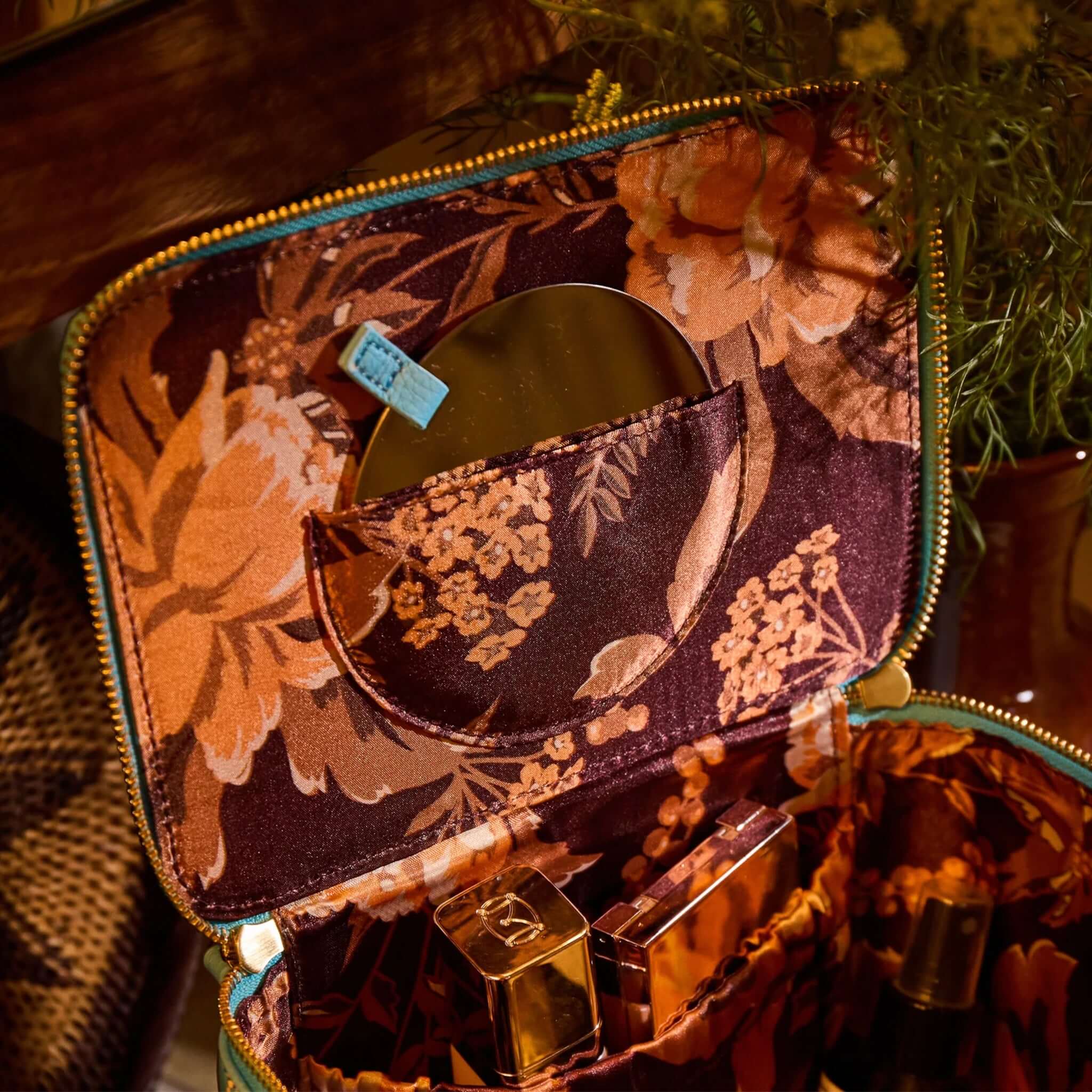 Interior view of Sage x Clare Bonny Medium Vanity Case - Turquoise showcasing floral print and beauty essentials.