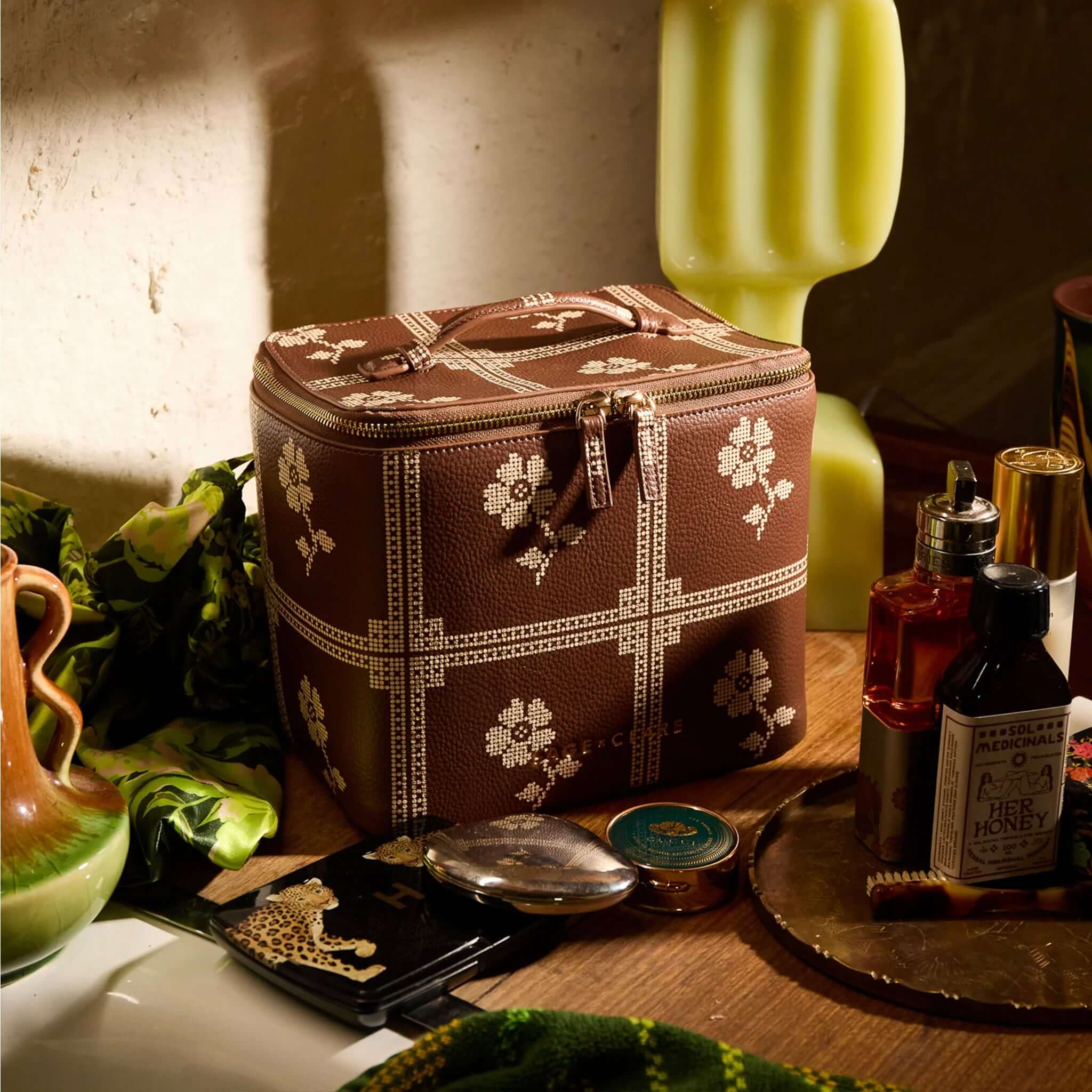 Sage x Clare Bonny Medium Vanity Case - Umber displayed with beauty products on a table.