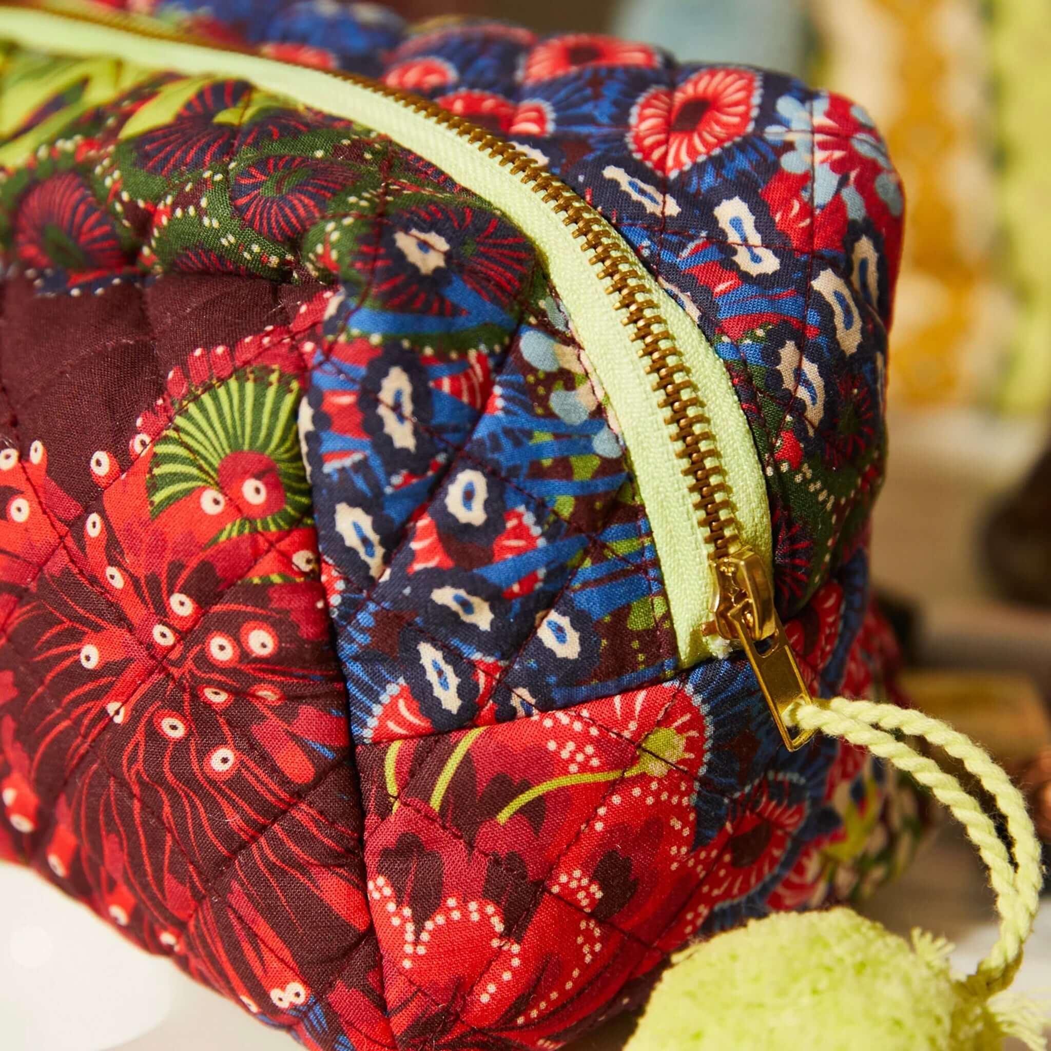 Sage x Clare Cora Organic Cotton Beauty Bag featuring a bold floral print and lime green tassel zip pull.