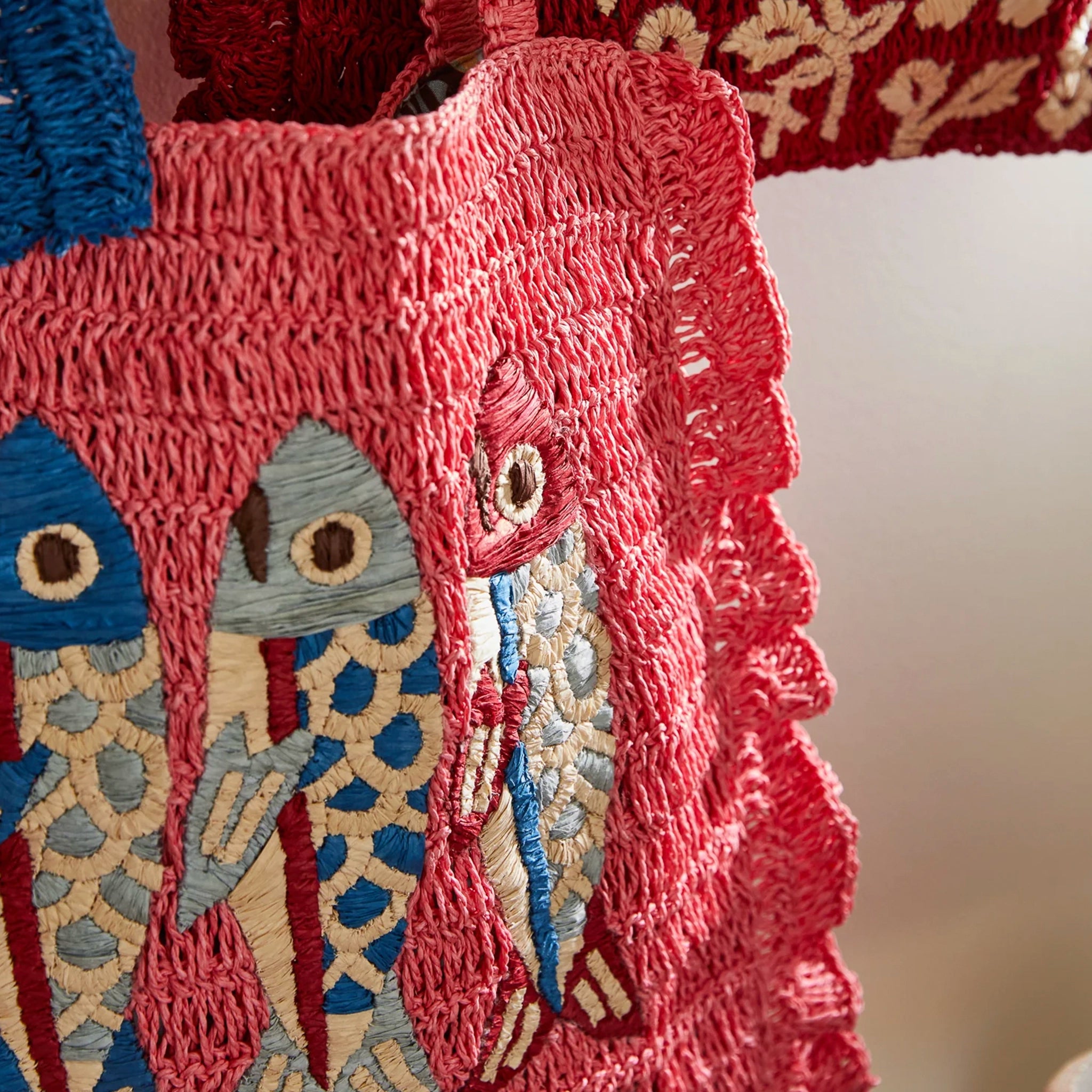 Close-up of a textured fabric with embroidered fish design on a red background