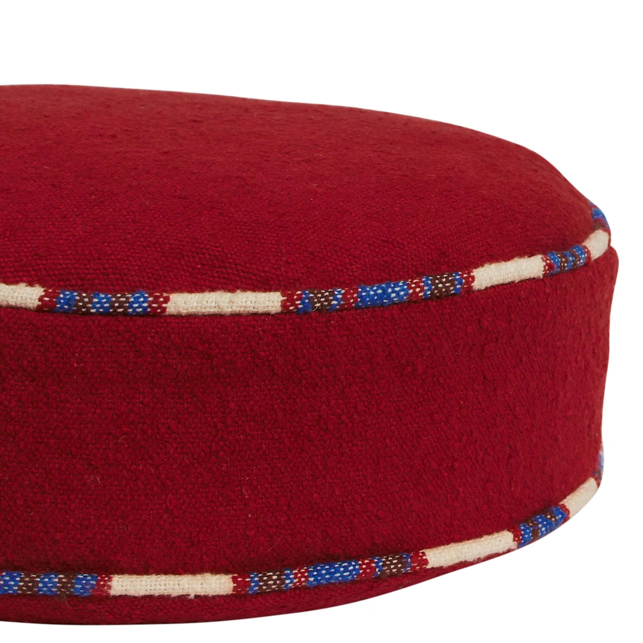 Red fabric cushion with decorative band on a white background