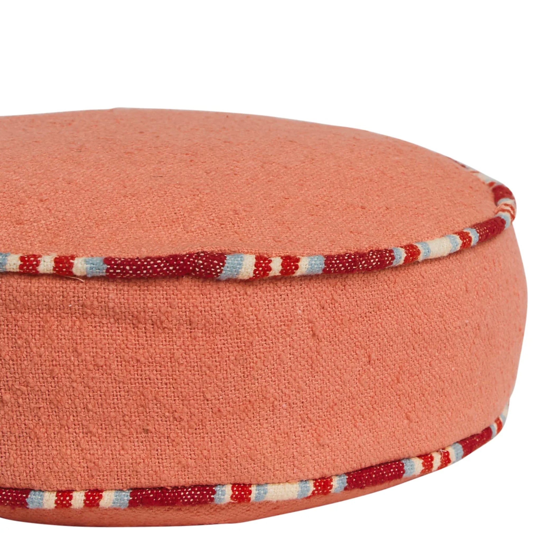 Round pink cushion with a striped trim on a white background