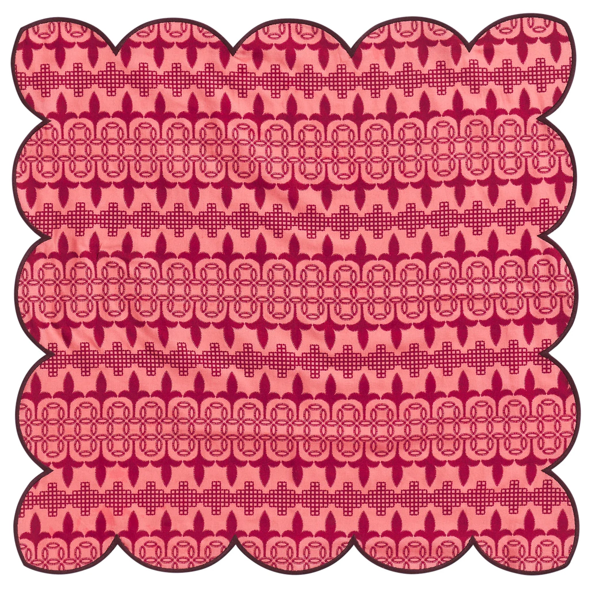 Decorative pink napkin with scalloped edge and intricate pattern