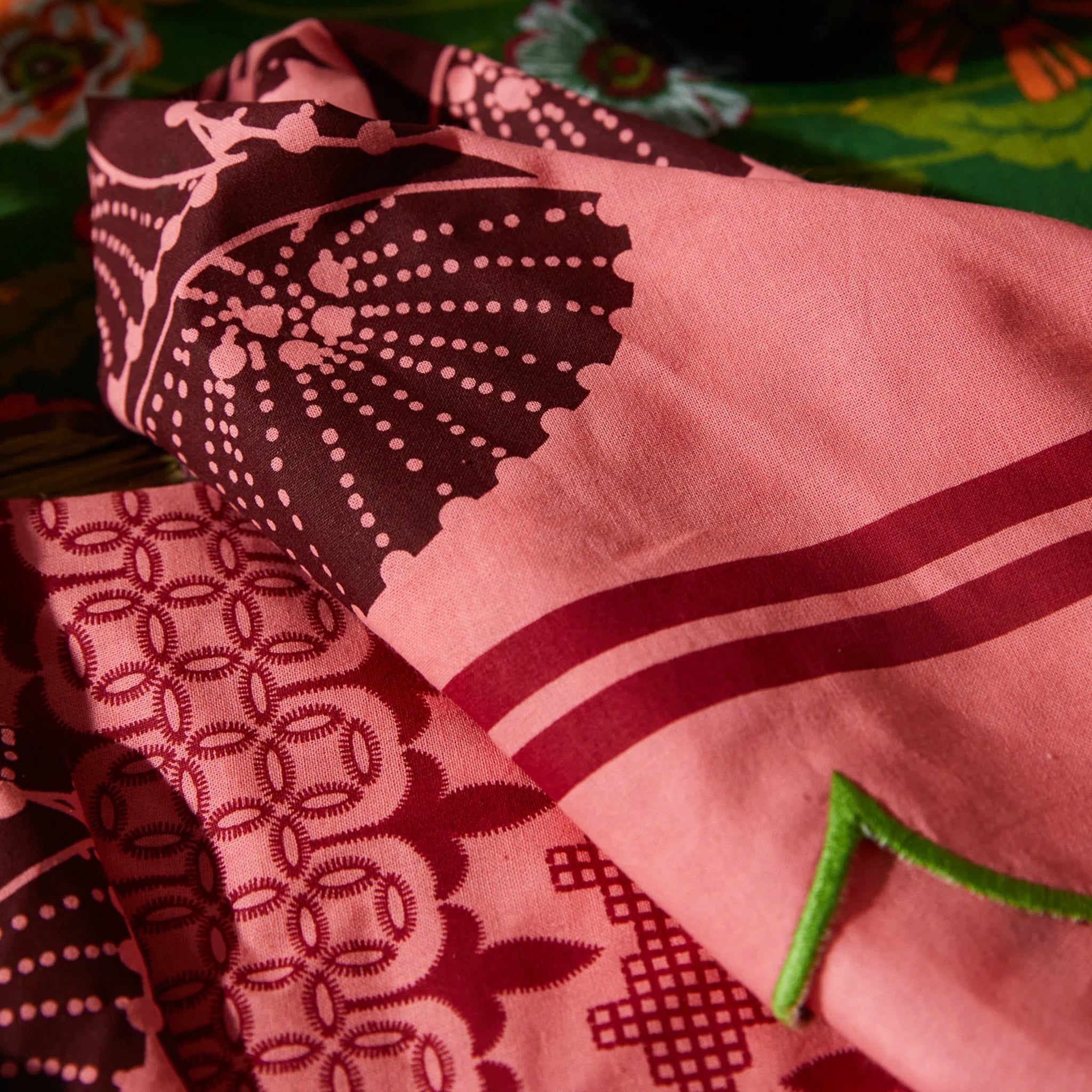 Close-up of a pink napkins with black patterns on a green background
