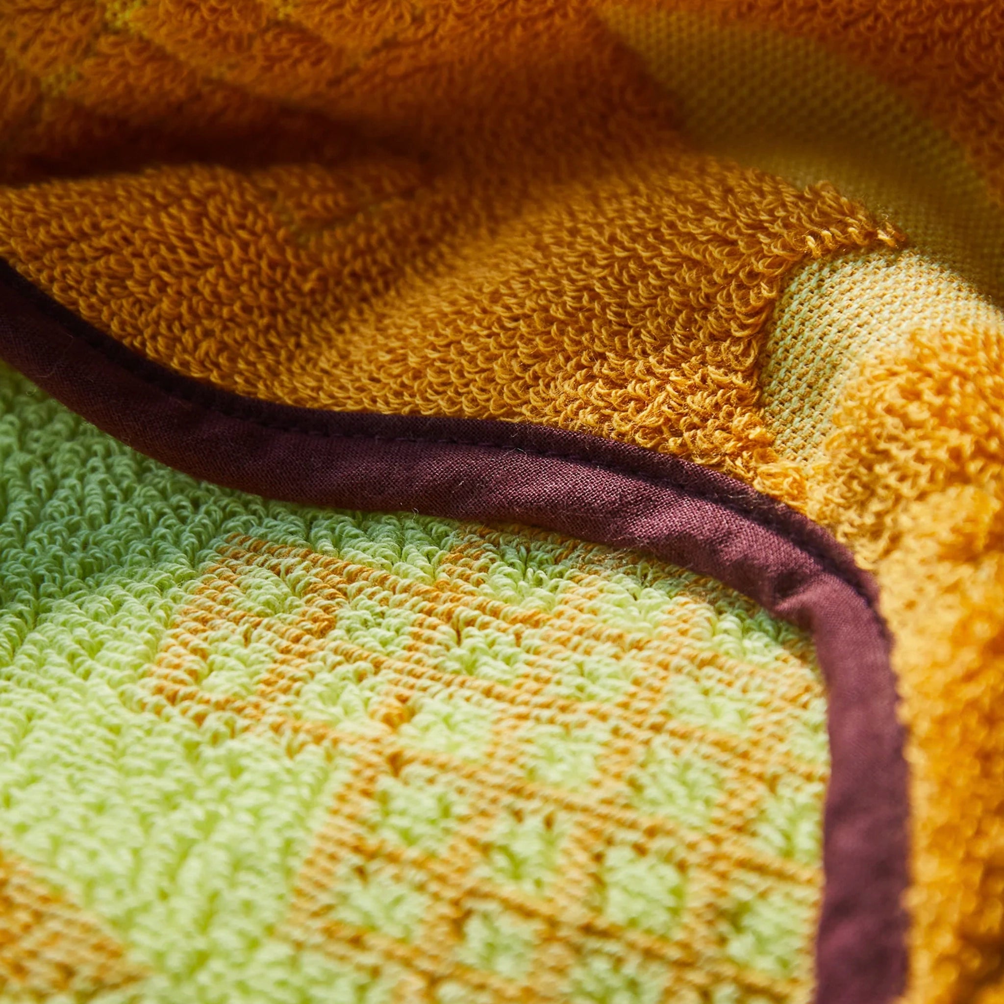 Close-up of a textured fabric with green, brown, and purple colors.