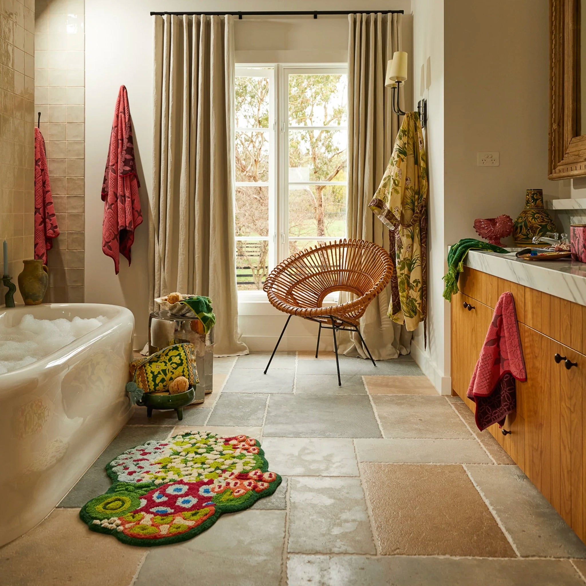 Bathroom with a bathtub, rug, chair, and window