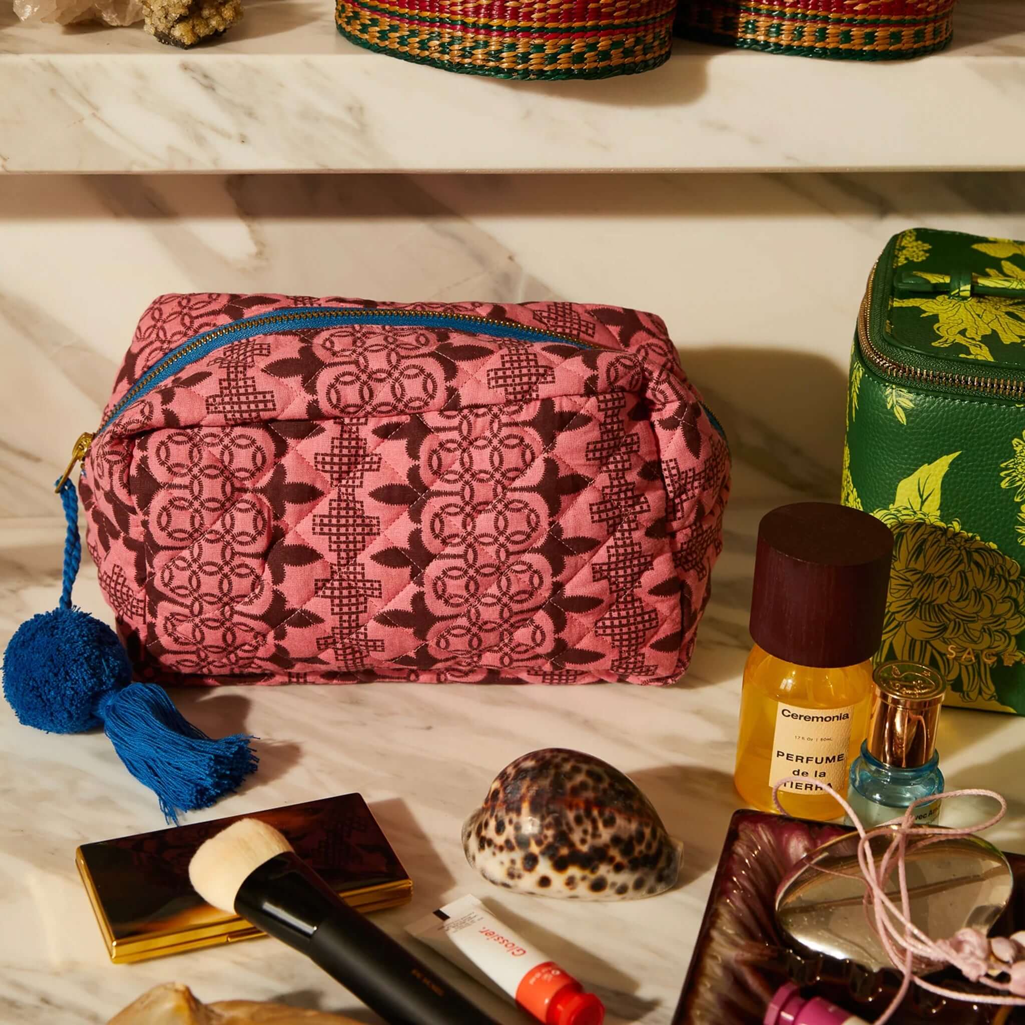 Alt Tag: Sage x Clare Esme Organic Cotton Beauty Bag pink quilted makeup bag with tassel on vanity, GOTS organic cotton travel toiletry case