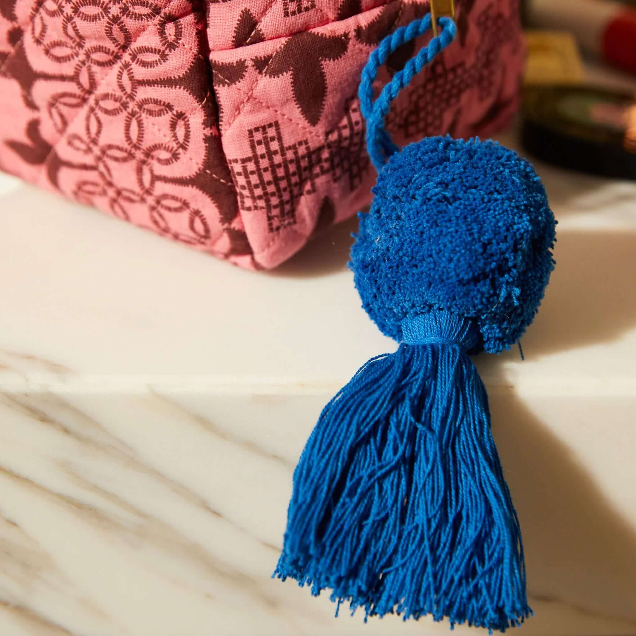 Alt Tag: Sage x Clare Esme Organic Cotton Beauty Bag close-up of pink quilted fabric with blue tassel detail