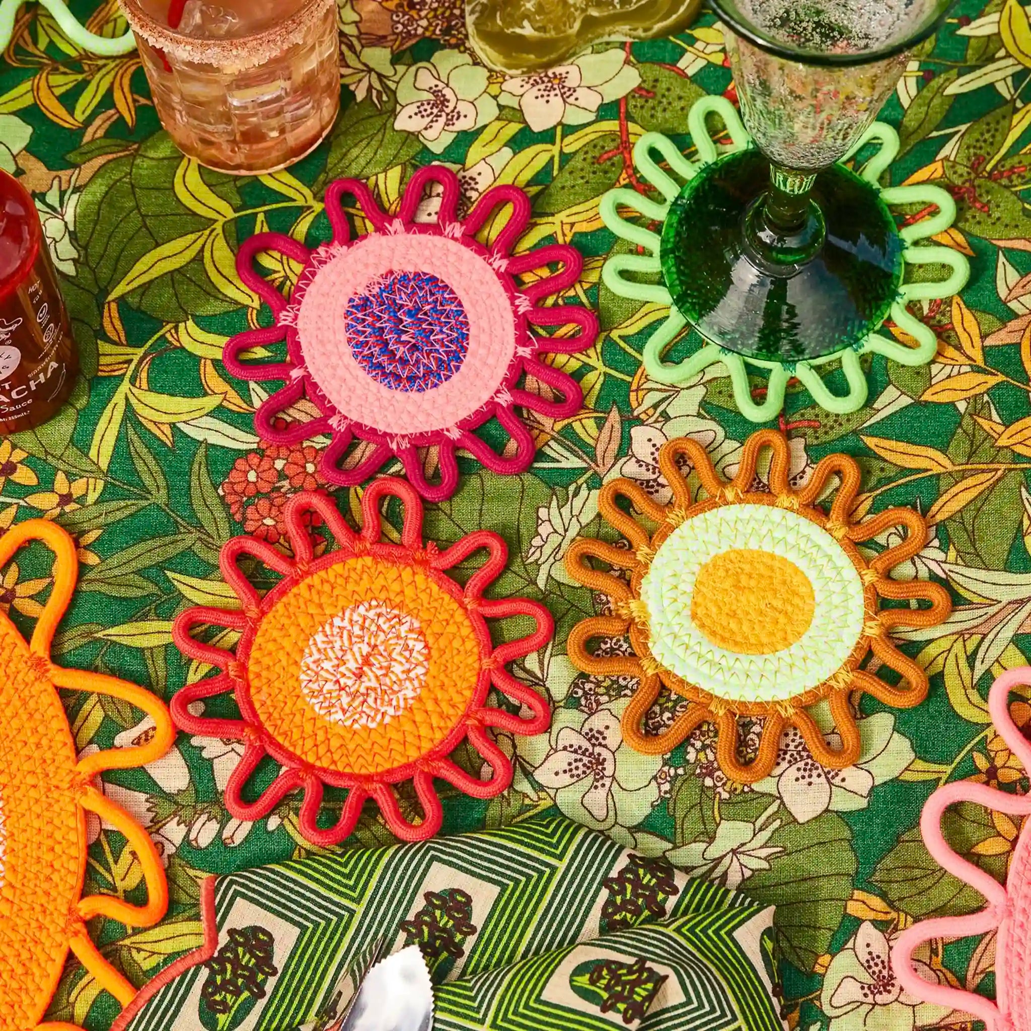 Colorful sun-shaped coasters on a patterned tablecloth