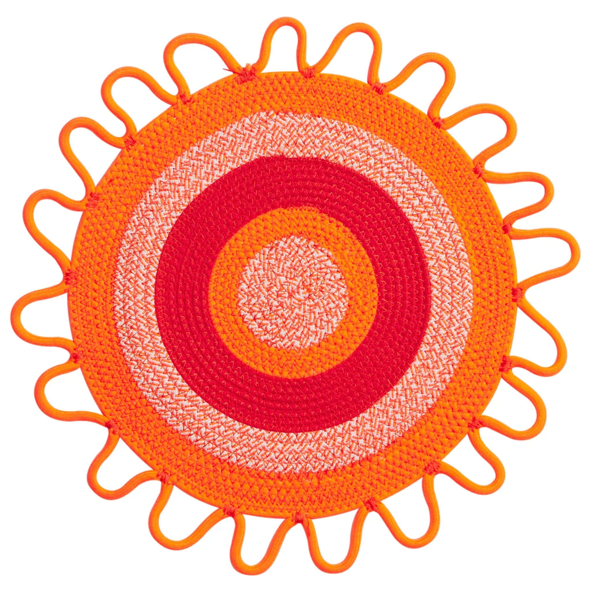 Round woven placemat with concentric circle design in orange, red, and white on a white background