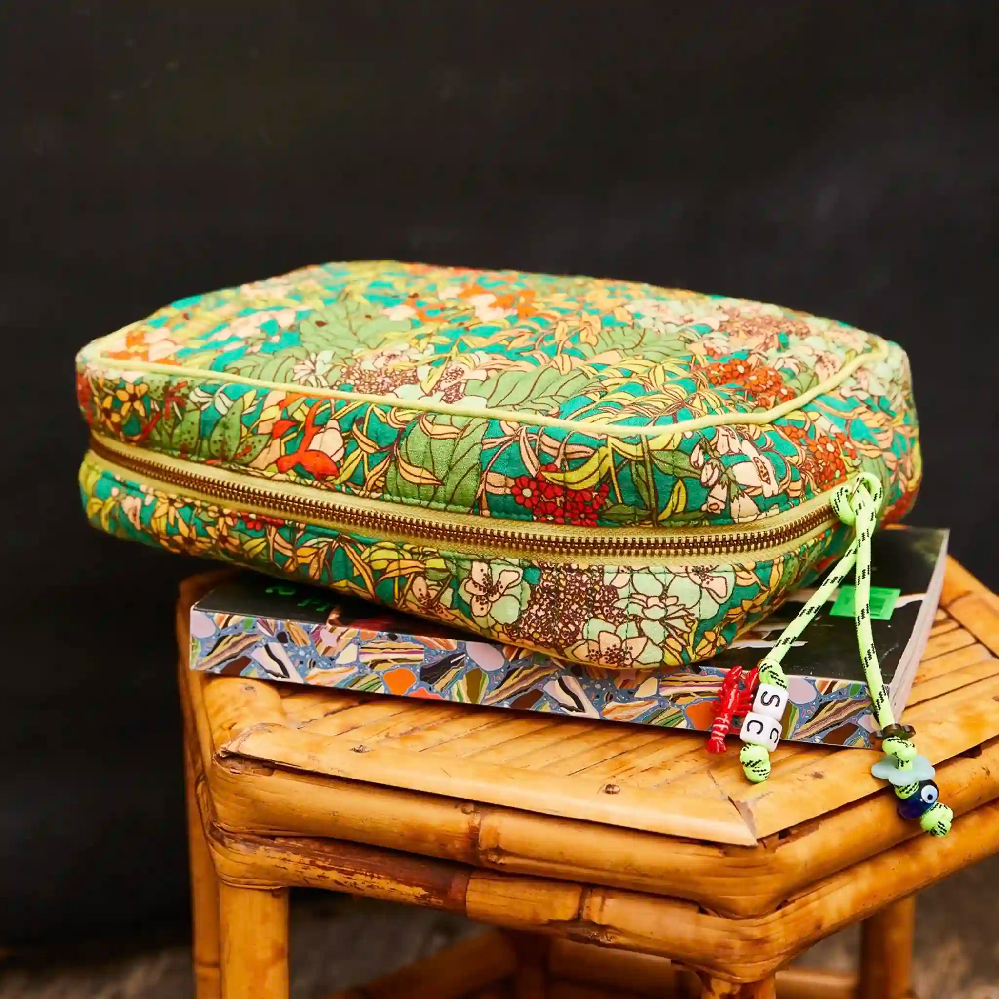 Colorful floral-patterned case on a wooden stool with a dark background