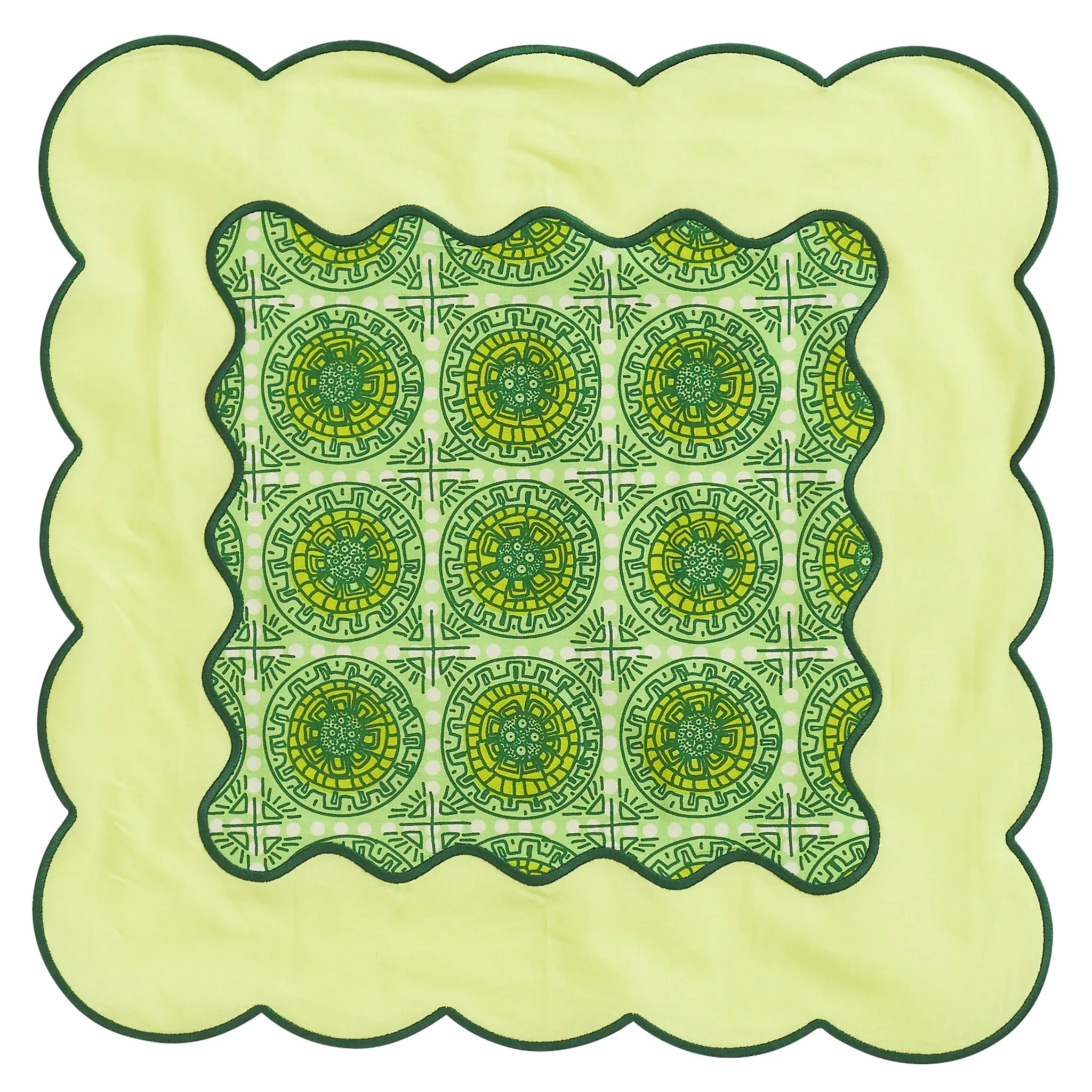 Decorative green and yellow patterned napkin with scalloped edges on a light green background
