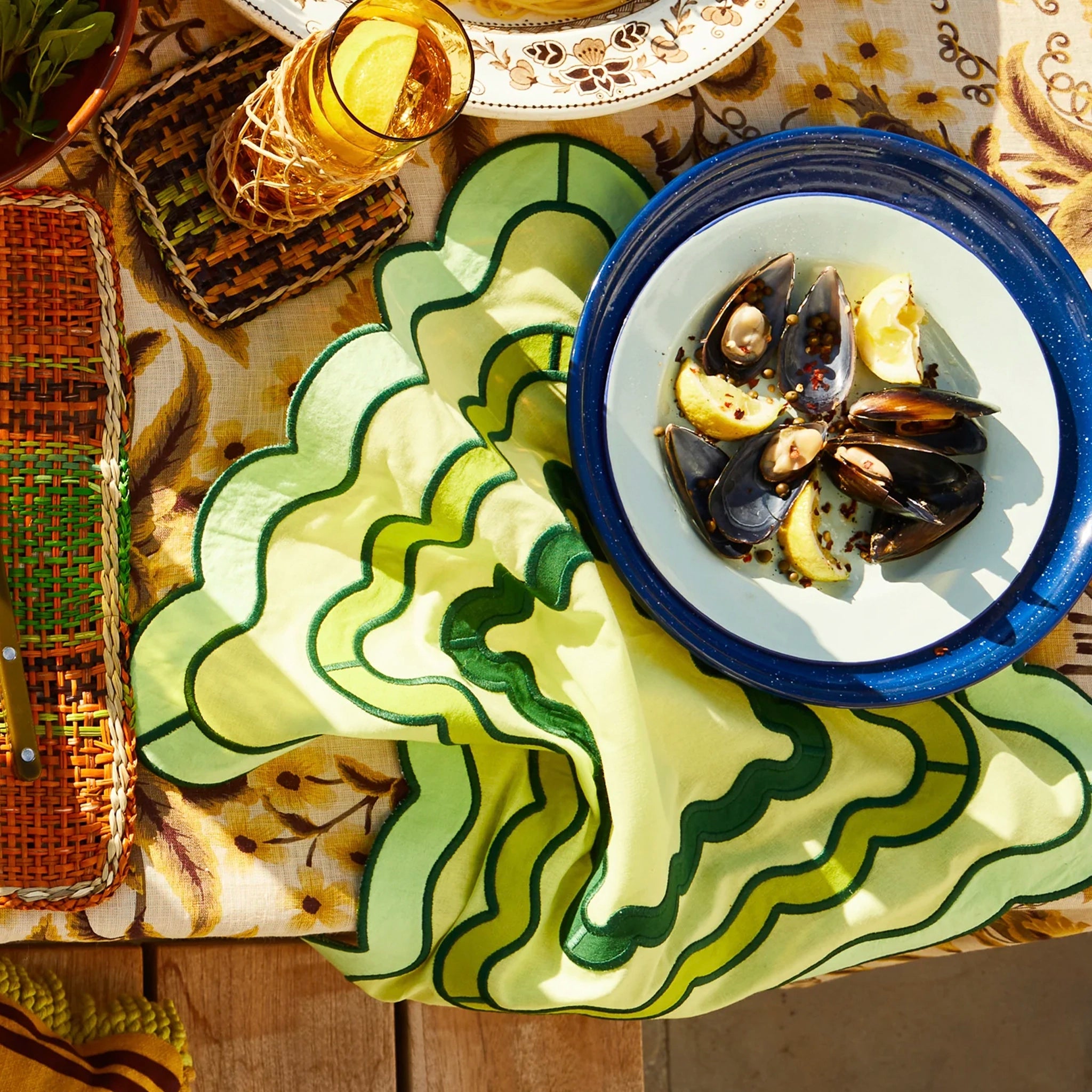 Table setting with a plate of mussels on a decorative napkin.