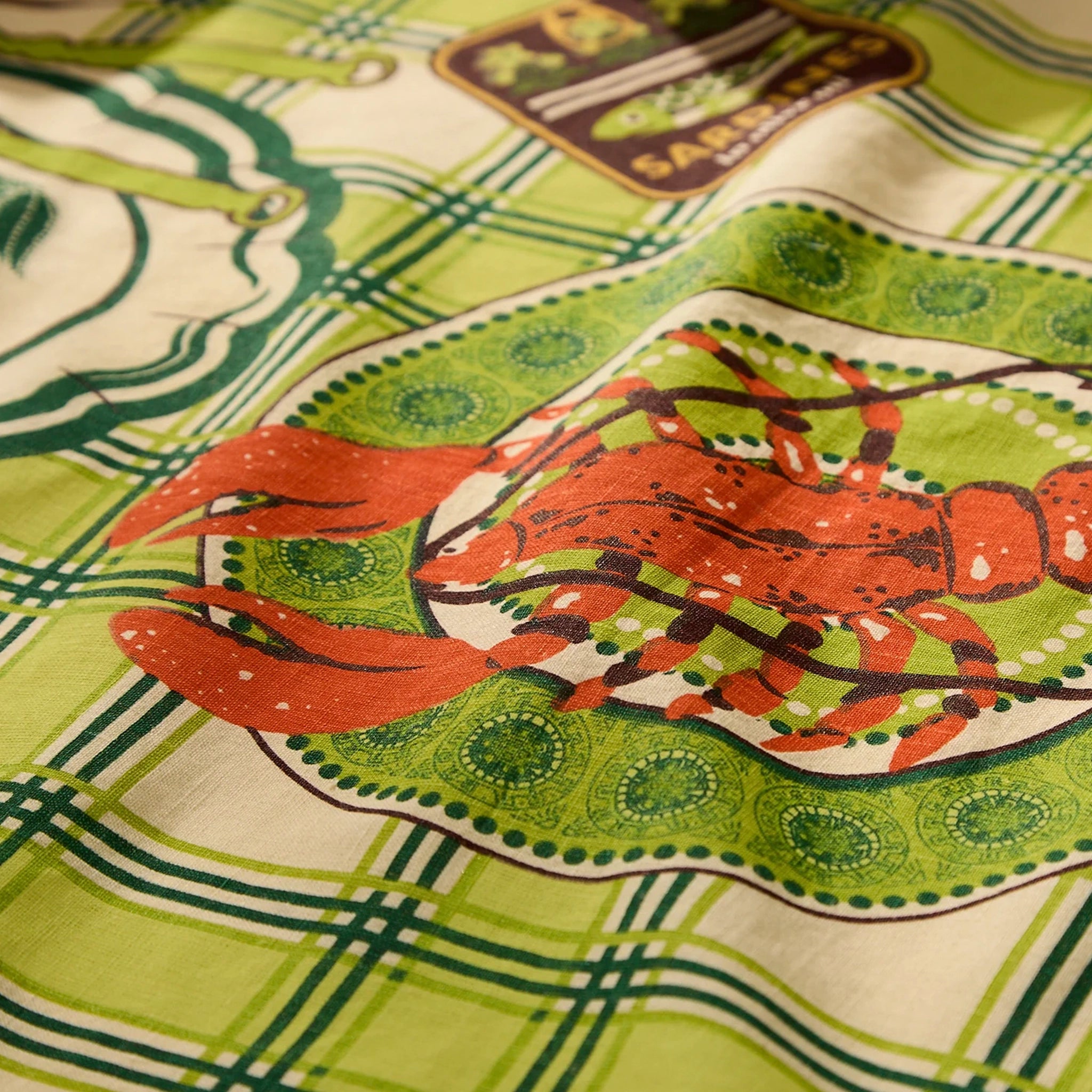 Close-up of a fabric with a lobster design and green plaid pattern