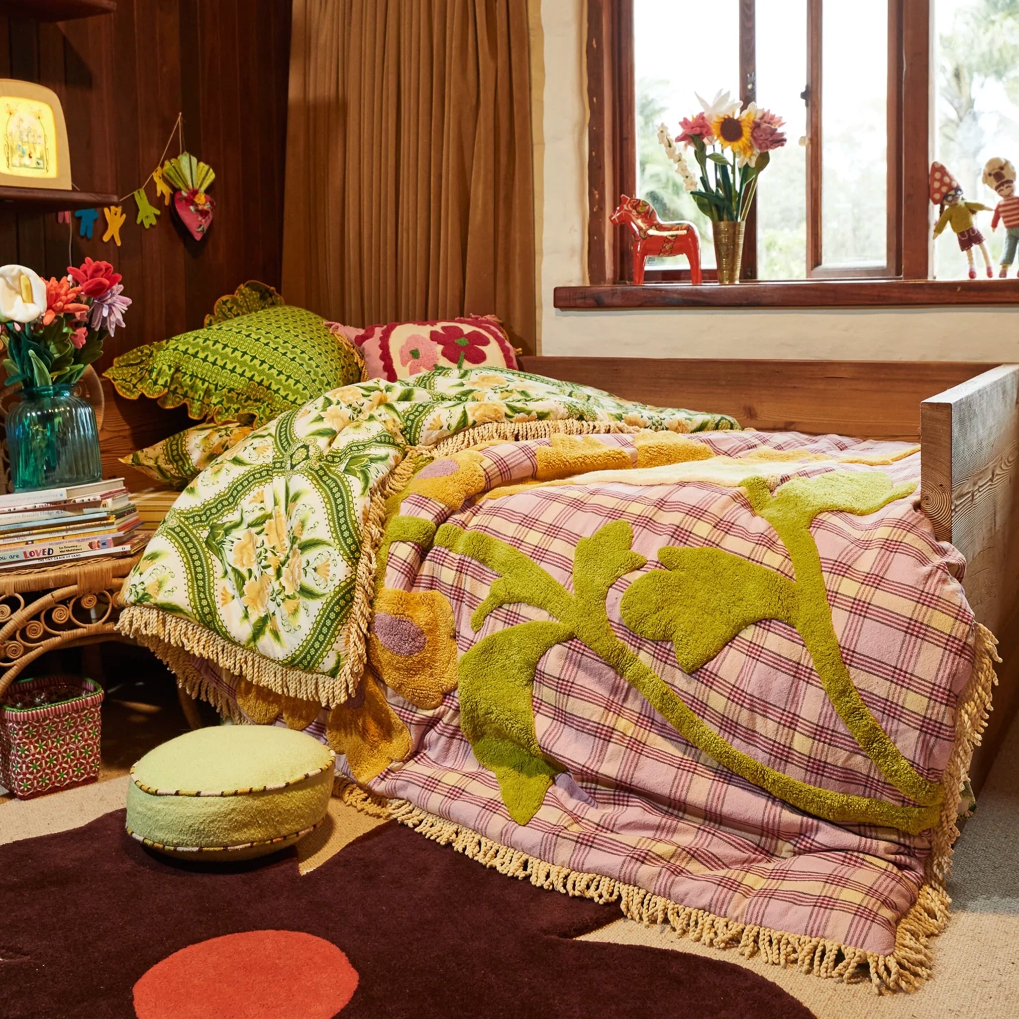 Bedroom with a bed covered in patterned bedding, surrounded by decorative items.