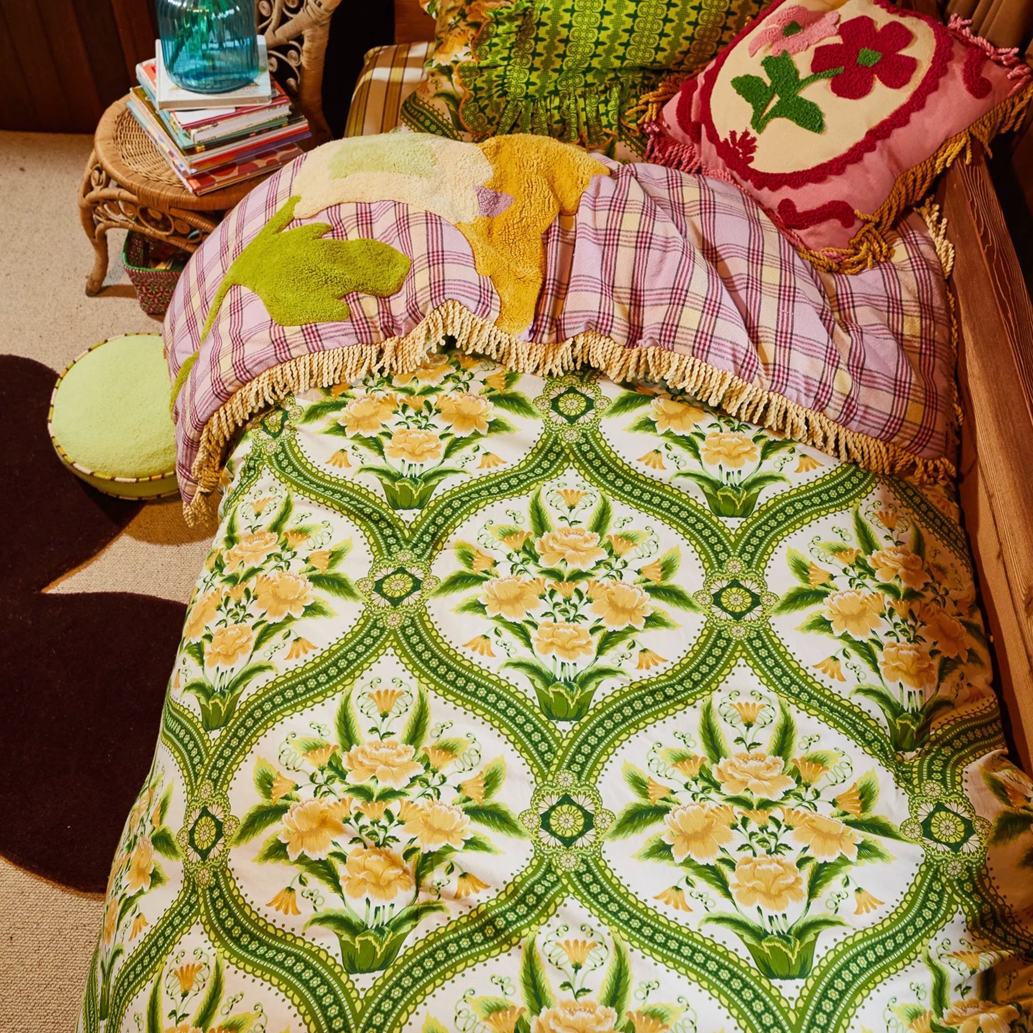 Floral-patterned quilt on a bed with decorative pillows in a cozy room.