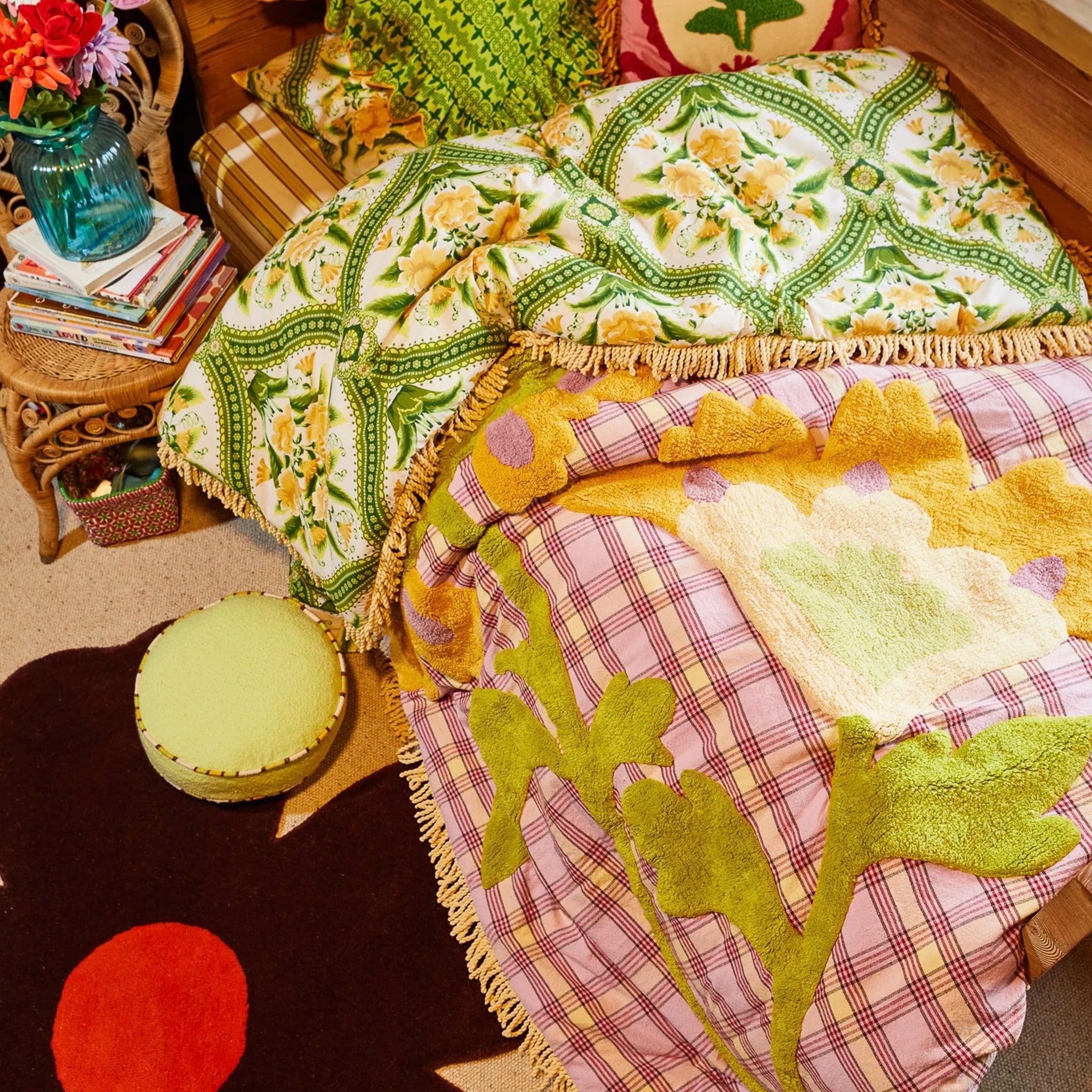 Colorful quilt with floral patterns on a bed in a bedroom setting.