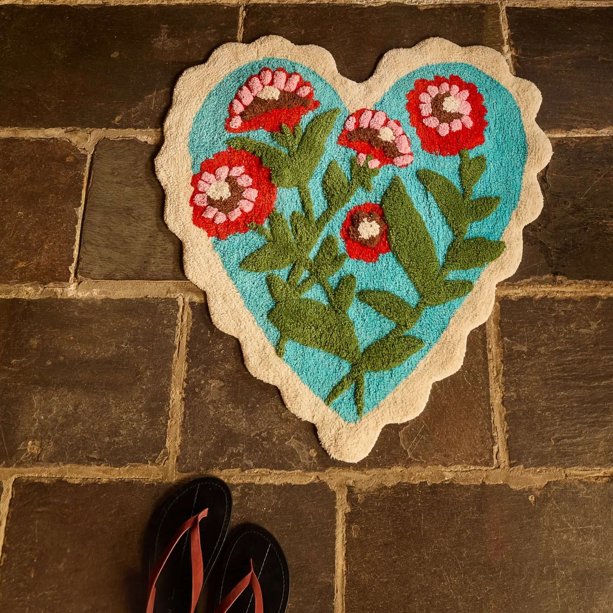 Sage x Clare Loretta Bath Mat in heart shape with red and pink flowers on turquoise background and cream border.