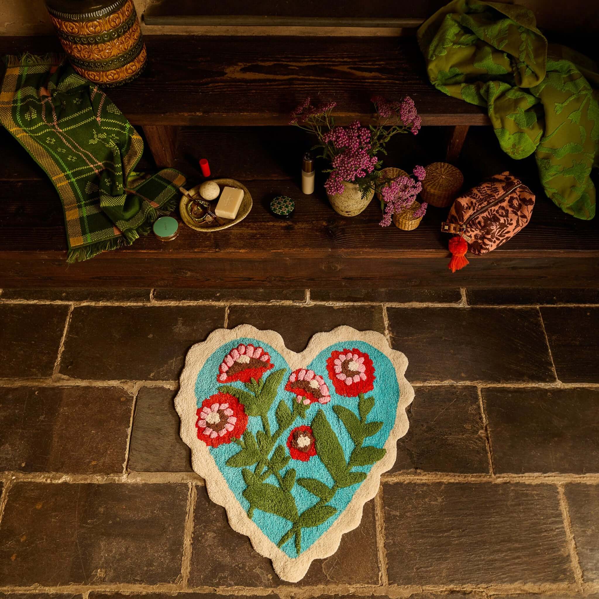 Sage x Clare Loretta Bath Mat in a heart shape with floral design on a turquoise background.