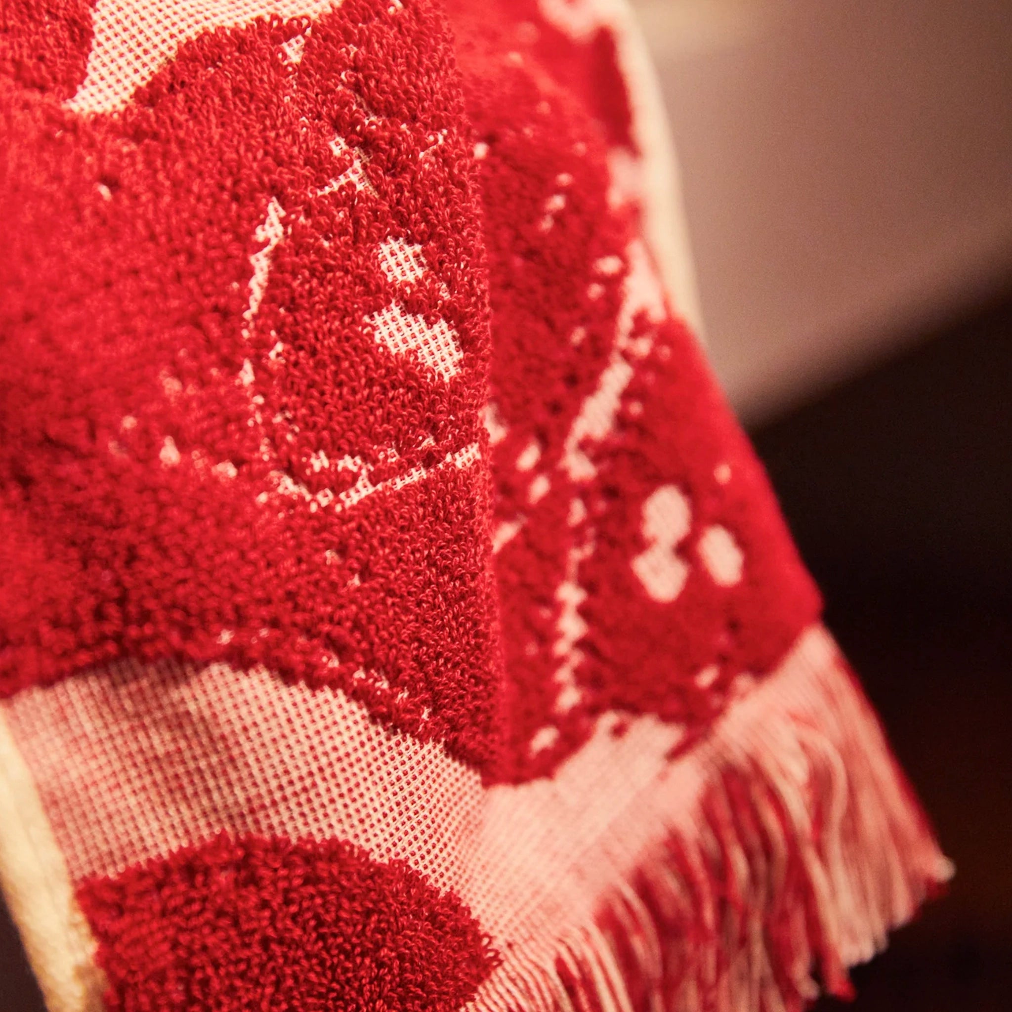 Close-up of a red and beige patterned fabric with a blurred background
