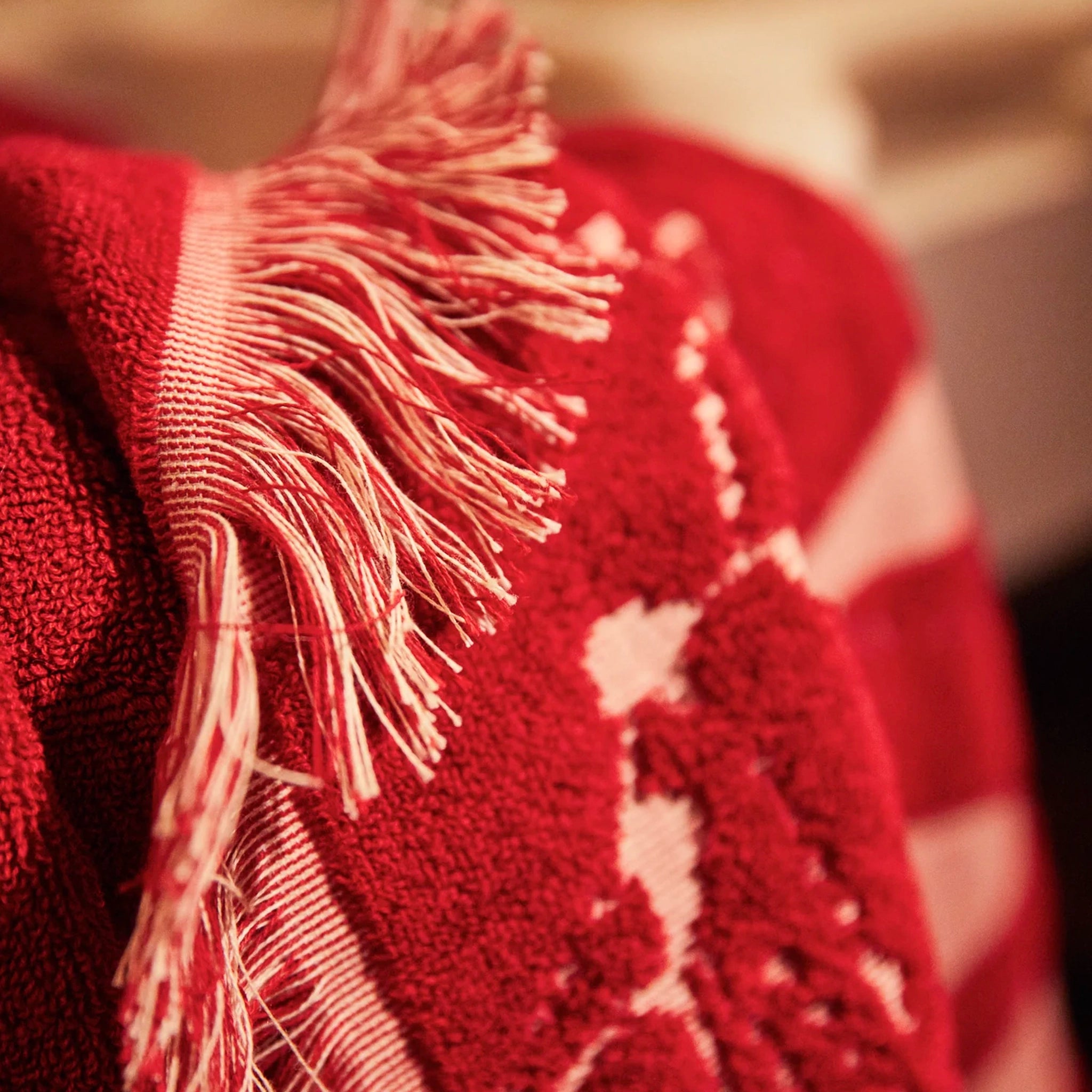 Close-up of a red textured fabric with fringes