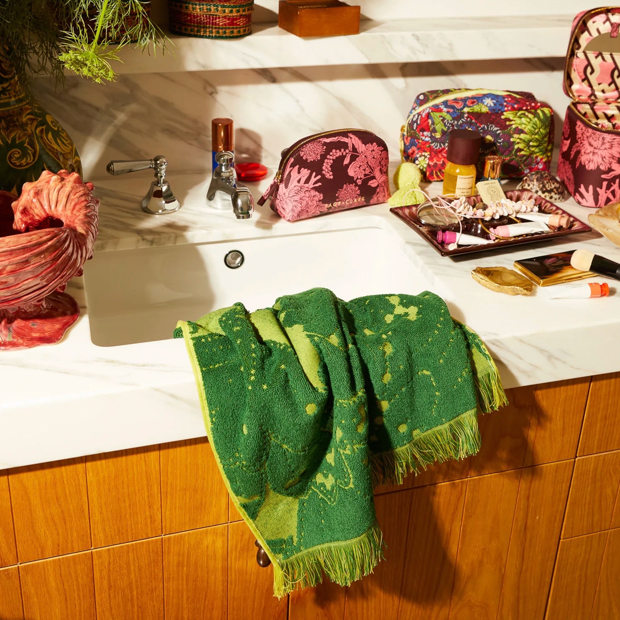Green towel draped over a sink with various items on a counter